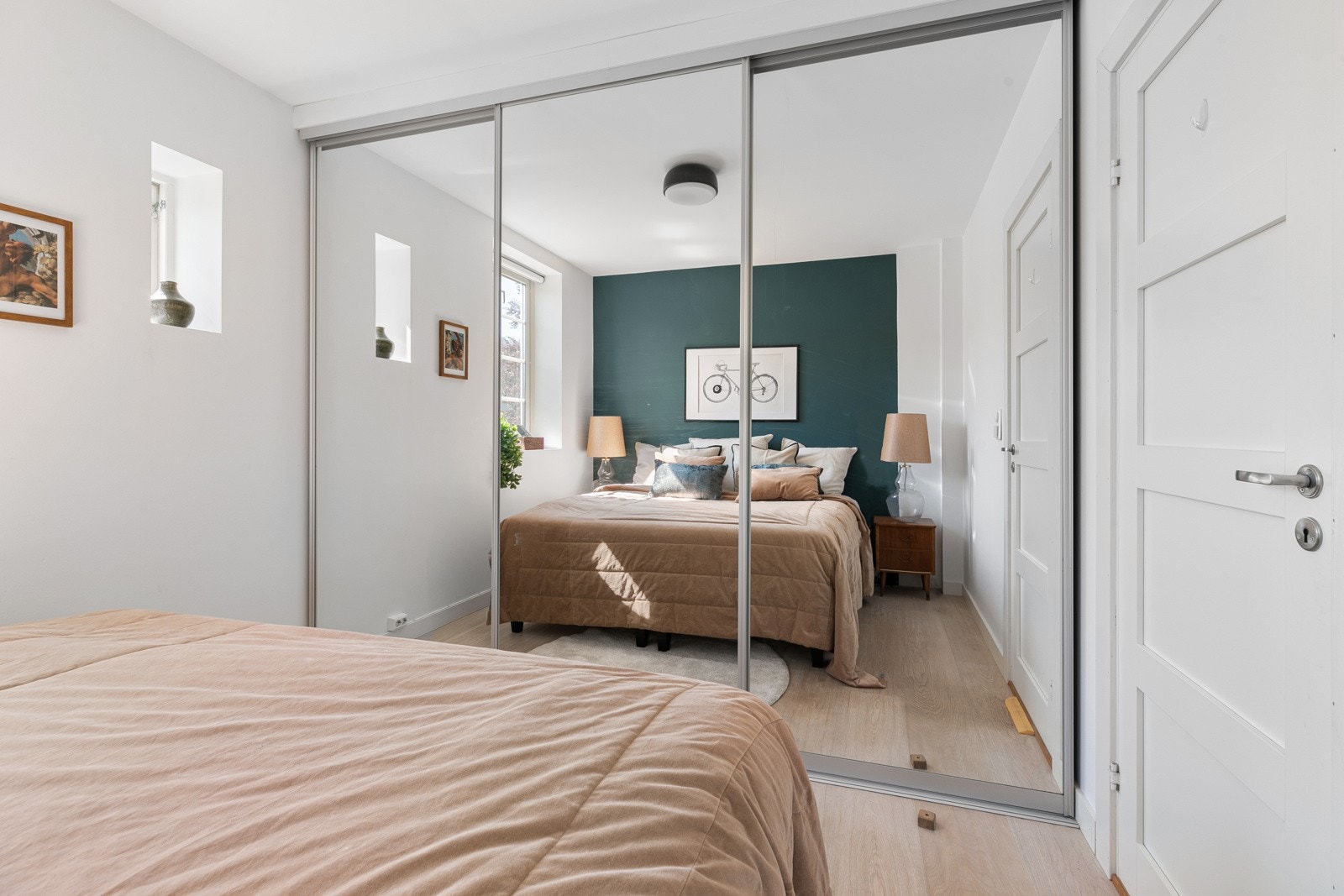 Romslig skyvedørsgarderobe med speil som sørger for godt med oppbevaringsplass for klær og tilbehør. Galleribilde