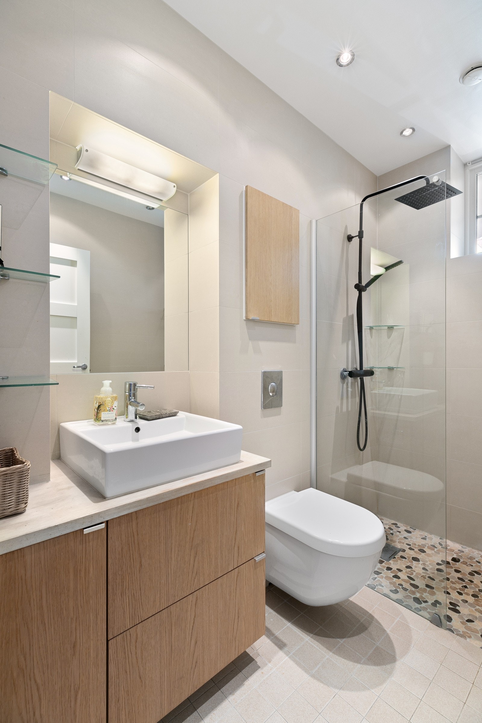 Badet inneholder servantbolle i heltreplate, innfelte speil med lys, veggmontert klosett og nedsenket dusjsjone. Galleribilde