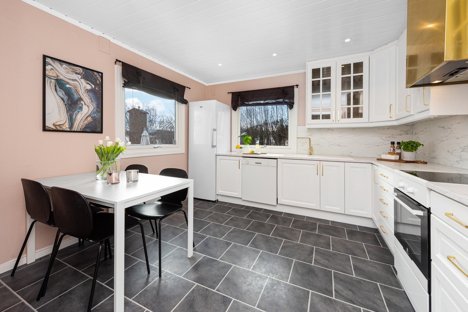 Kjøkkeninnredningen har hvite tidløse profilerte fronter, og benkeplate av laminat. Galleribilde