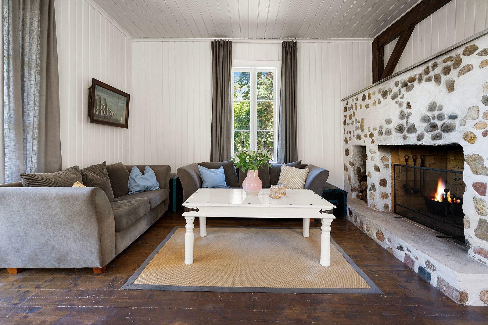 God plass til sofagruppe foran den majestetiske peisen. Galleribilde