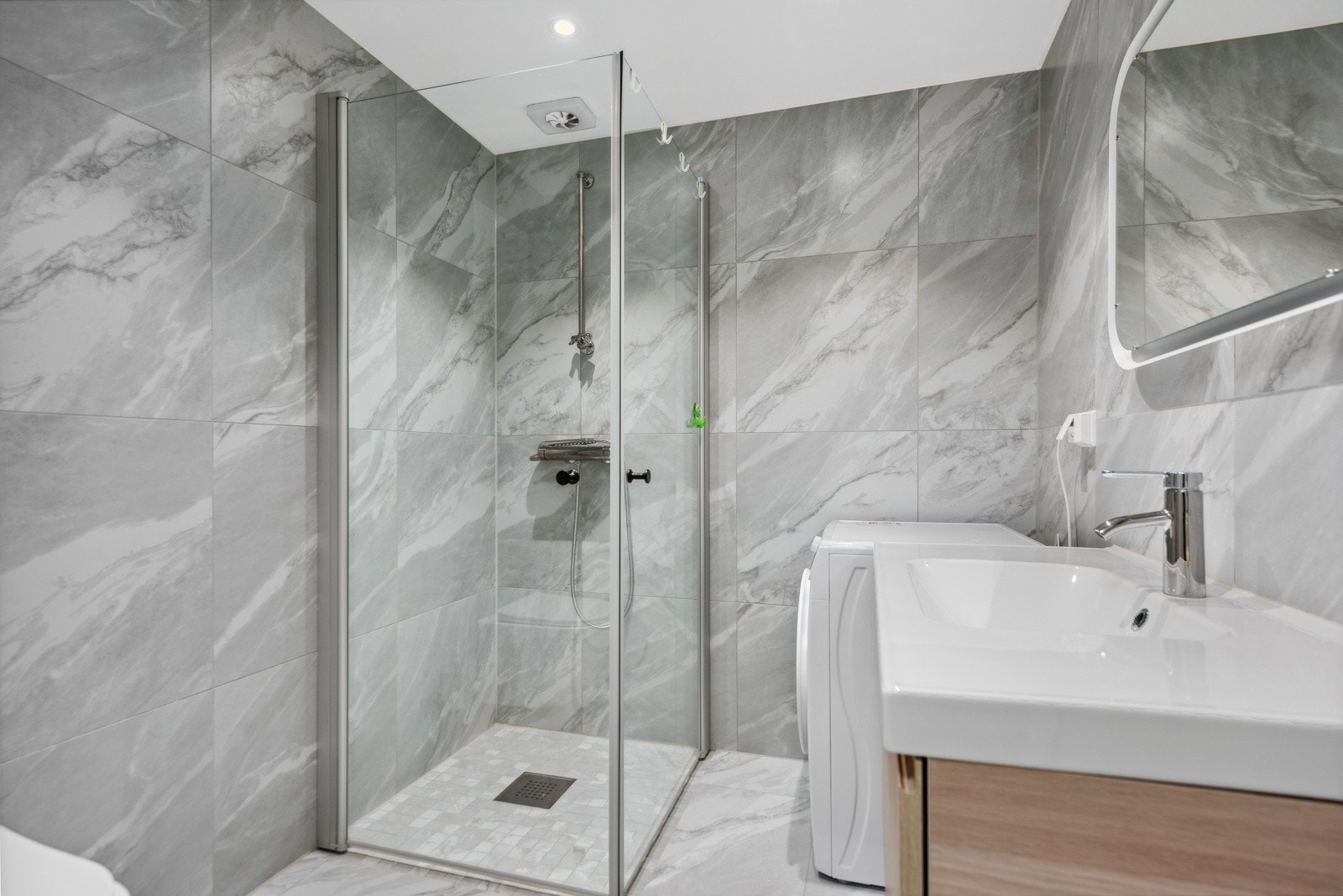 Badet i hybelen har vegghengt toalett, servant med skuffer under og dusjhjørne med innfellbare glassdører. Det er opplegg for vaskemaskin. Galleribilde