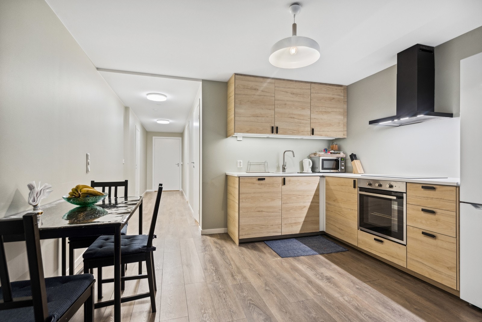 Kjøkkenet har moderne innredning og integrert platetopp, stekeovn og oppvasmaskin. Det er plass til spisebord. Galleribilde