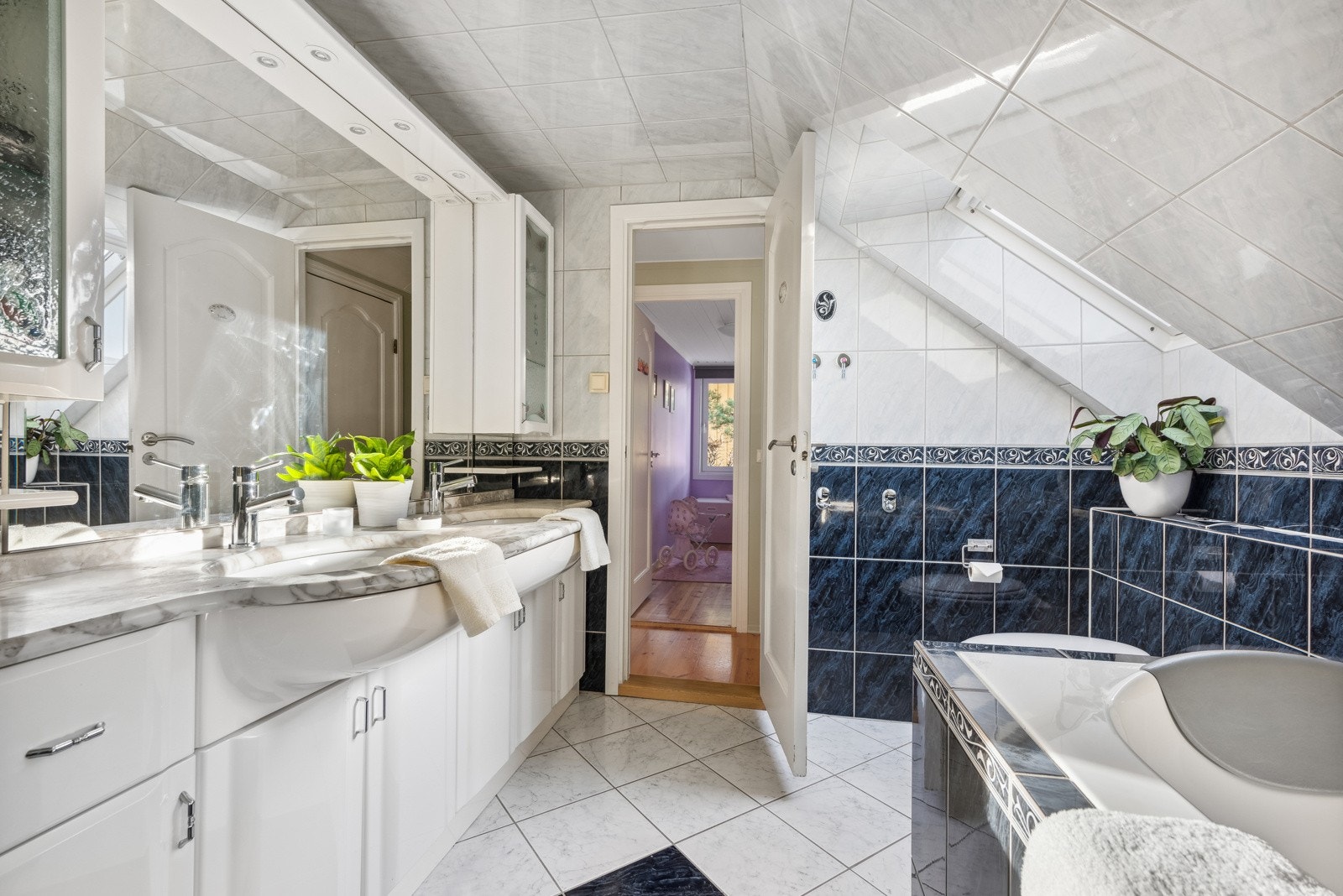 Videre har badet vegghengt toalett og baderomsinnredning med dobbel servant og godt med oppbevaringsplass. Galleribilde