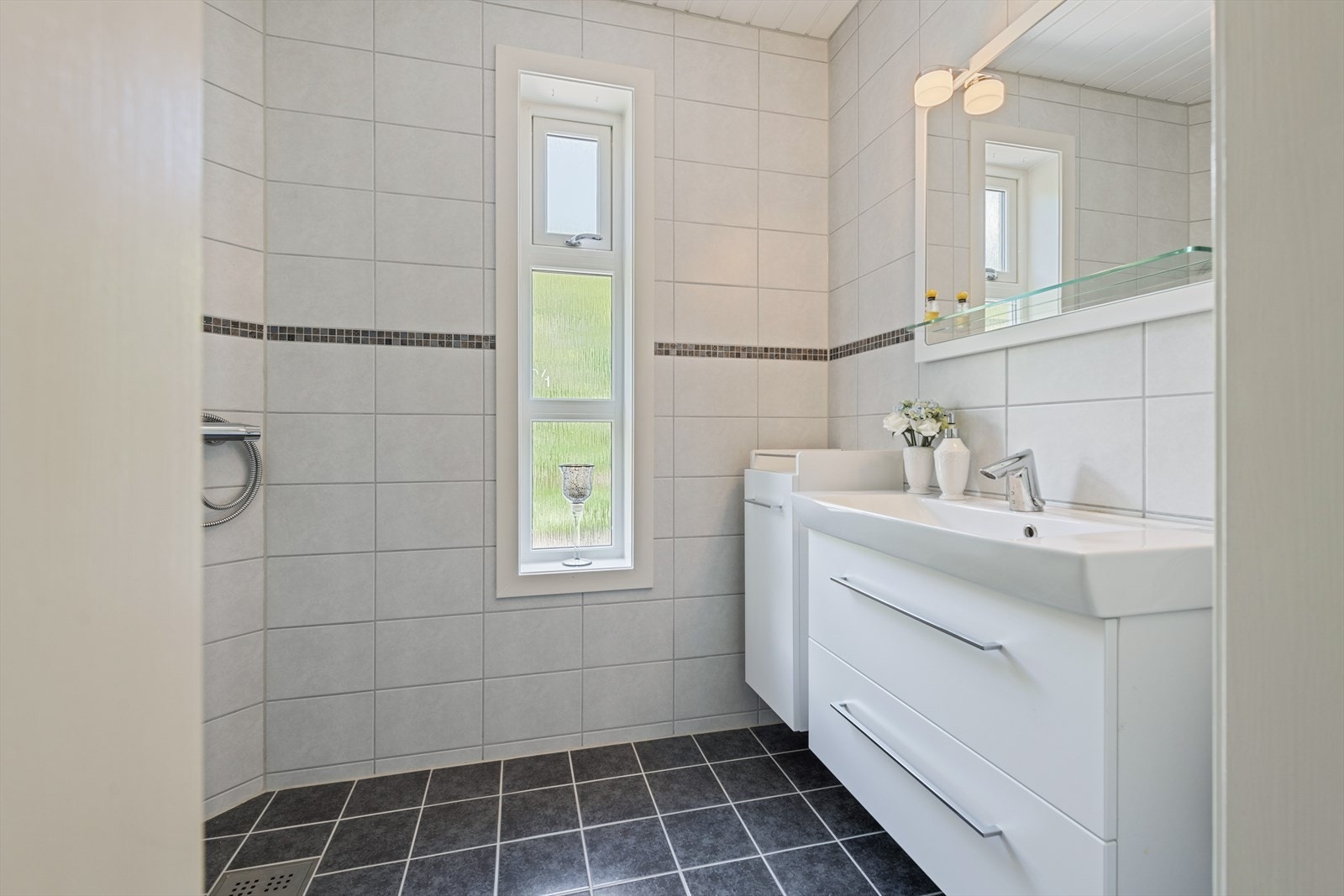 Dette badet ligger i hovedetasjen, noe som er praktisk både i forhold til oppholdsrom og gjester. Galleribilde