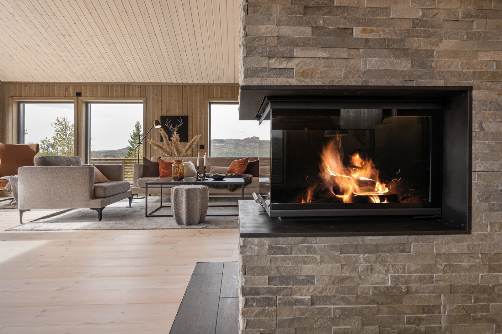 Nydelig heltre furugulv i samspill med flammene fra peisen er med og skaper en lun stemning. Galleribilde