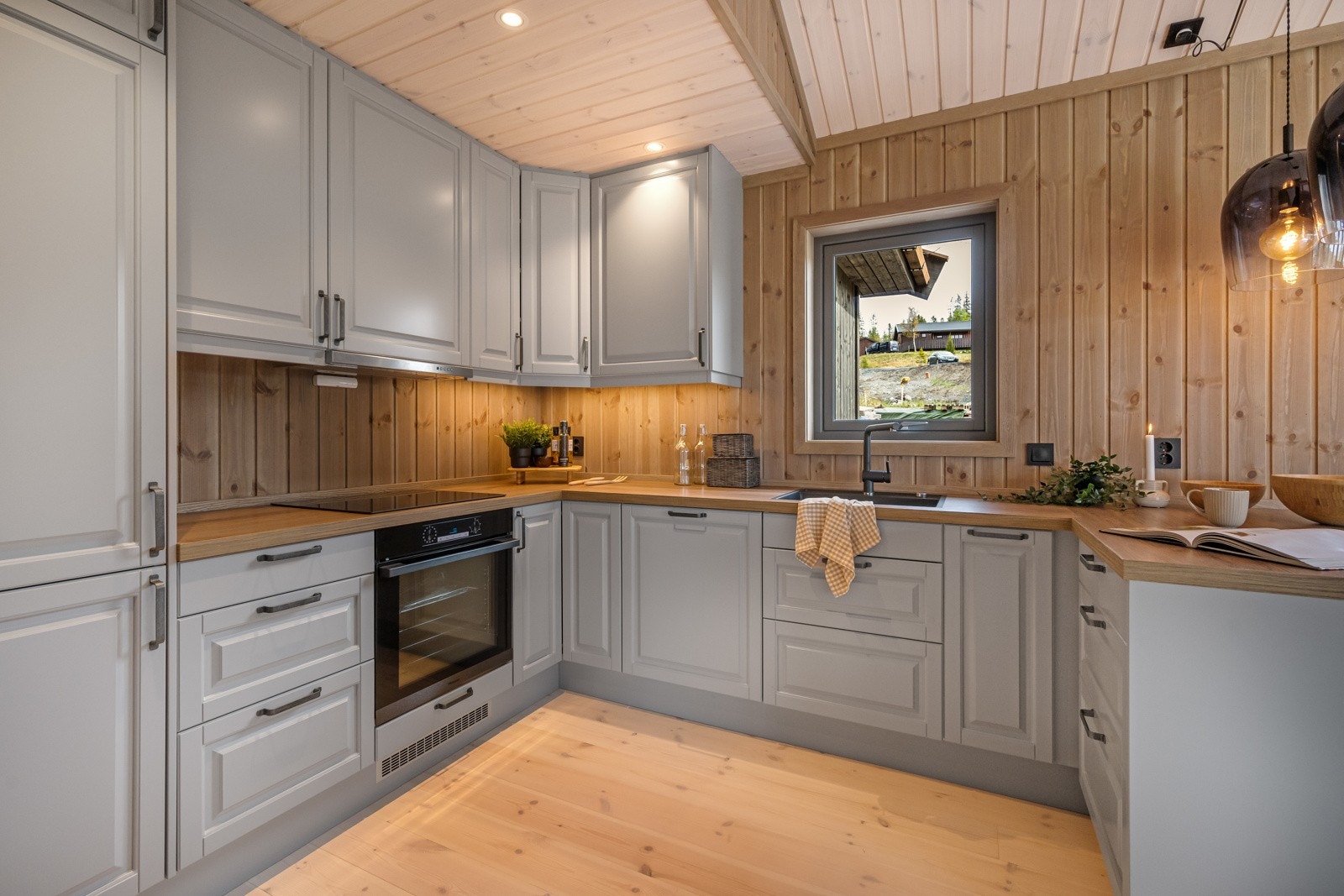 Pent kjøkken fra Epoq i grå utførelse. Her finner du blant annet induksjon koketopp, svart oppvaskkum og svart kjøkkenarmatur. Galleribilde