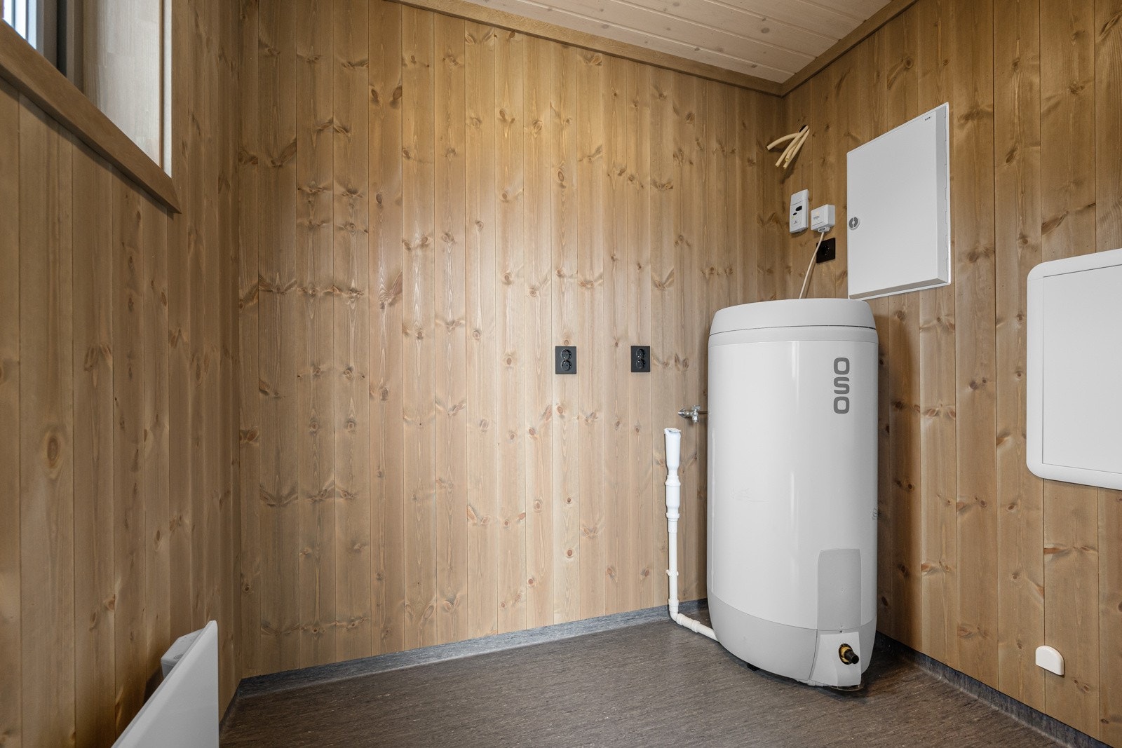 Vaskerom med egen inngangsdør i yttervegg er et kombi-rom, vaskerom/teknisk-rom, slik at bereder, skap for rør i rør system og sikringskap er plassert i dette rom Galleribilde