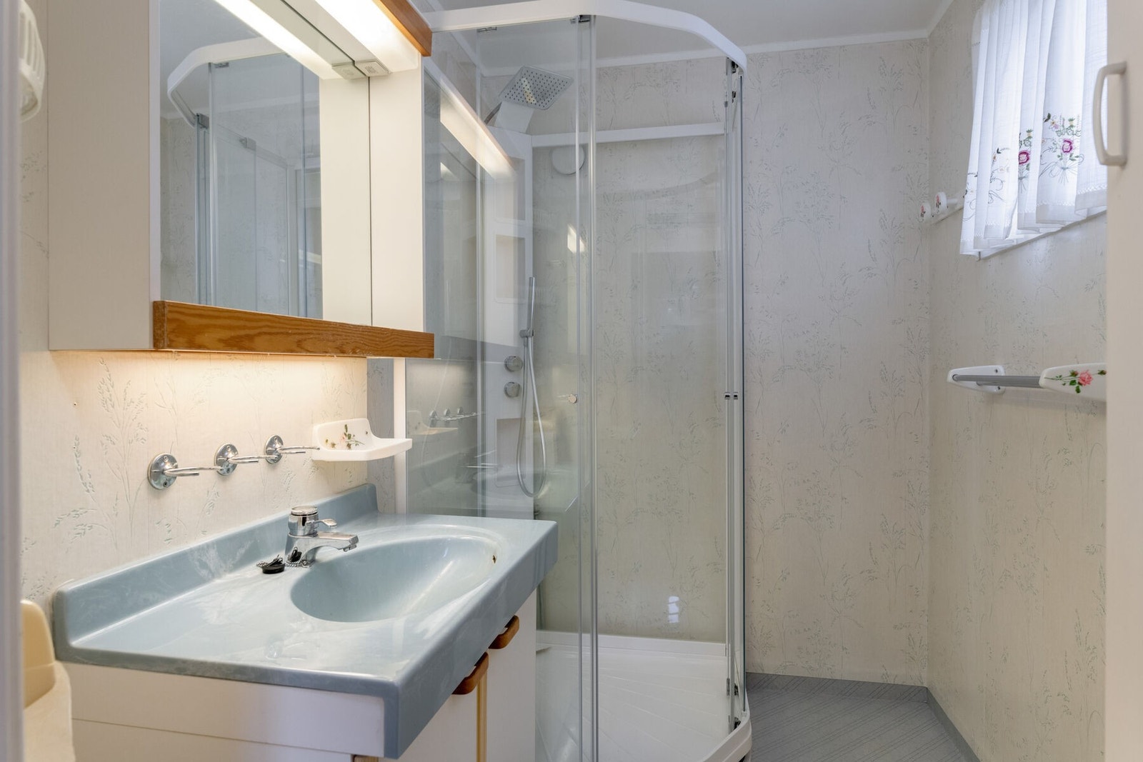 Badet i hovedetasjen har lys baderomsinnredning og dusjkabinett med takdusj Galleribilde