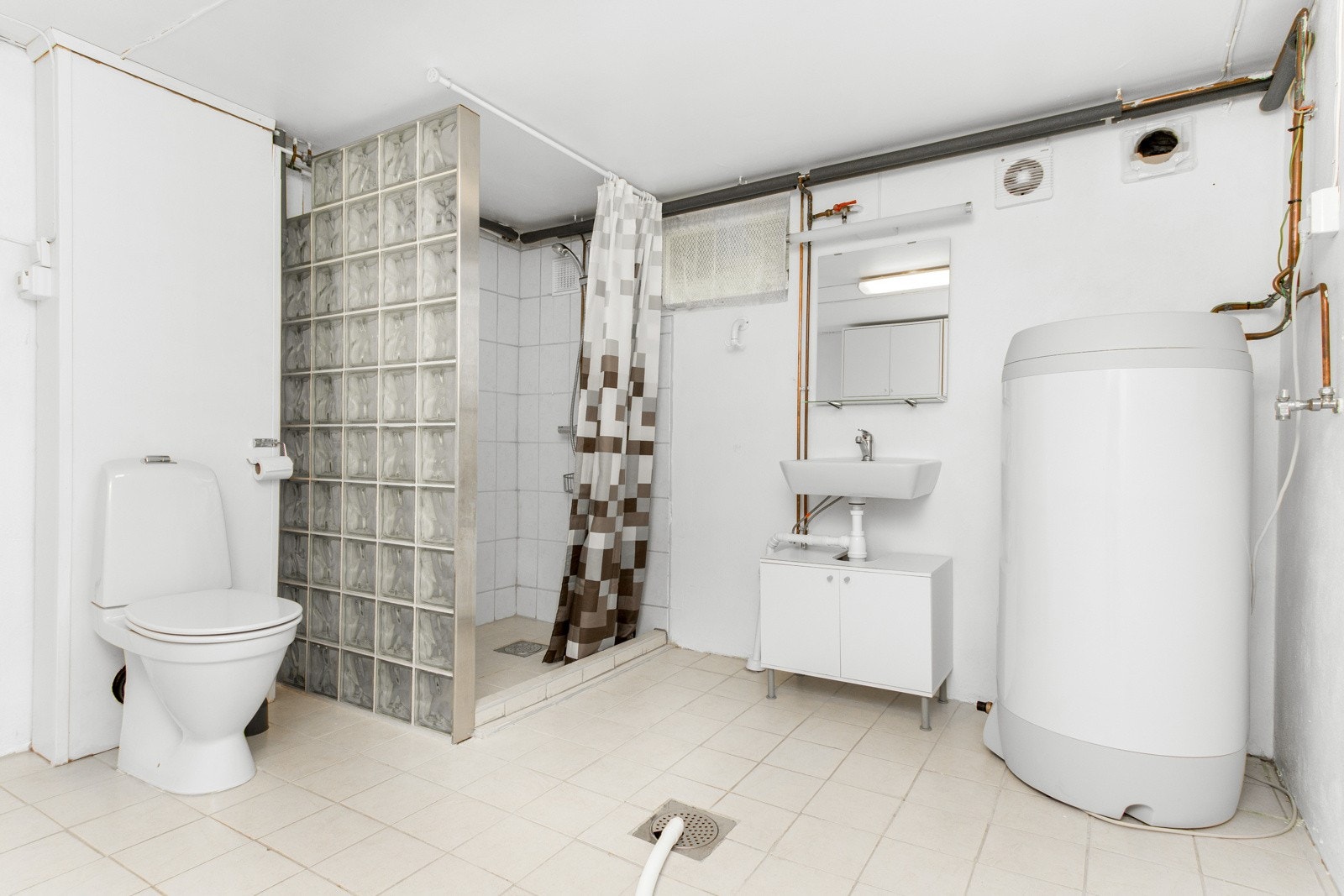 I kjelleretasjen ligger et kombinert bad/vaskerom som er innredet med toalett, servant, dusj og opplegg for vaskemaskin. Galleribilde