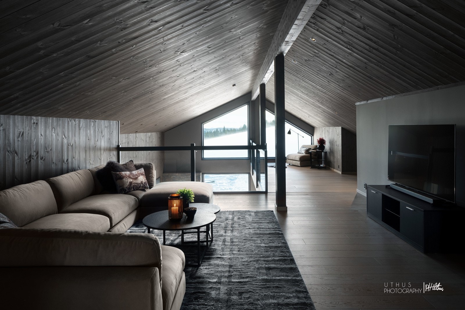 Loftstuen er delt sømløst inn i to avdelinger med en forhøyning. Galleribilde