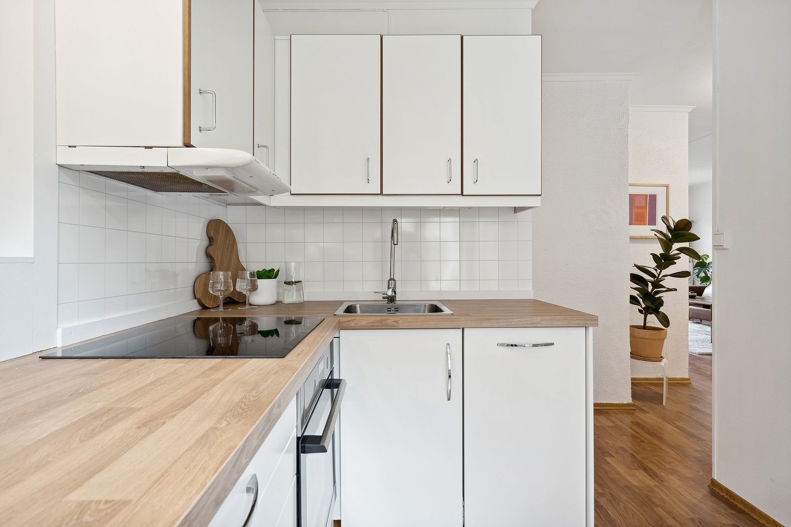 Separat kjøkken bestående av hvite fronter. Galleribilde