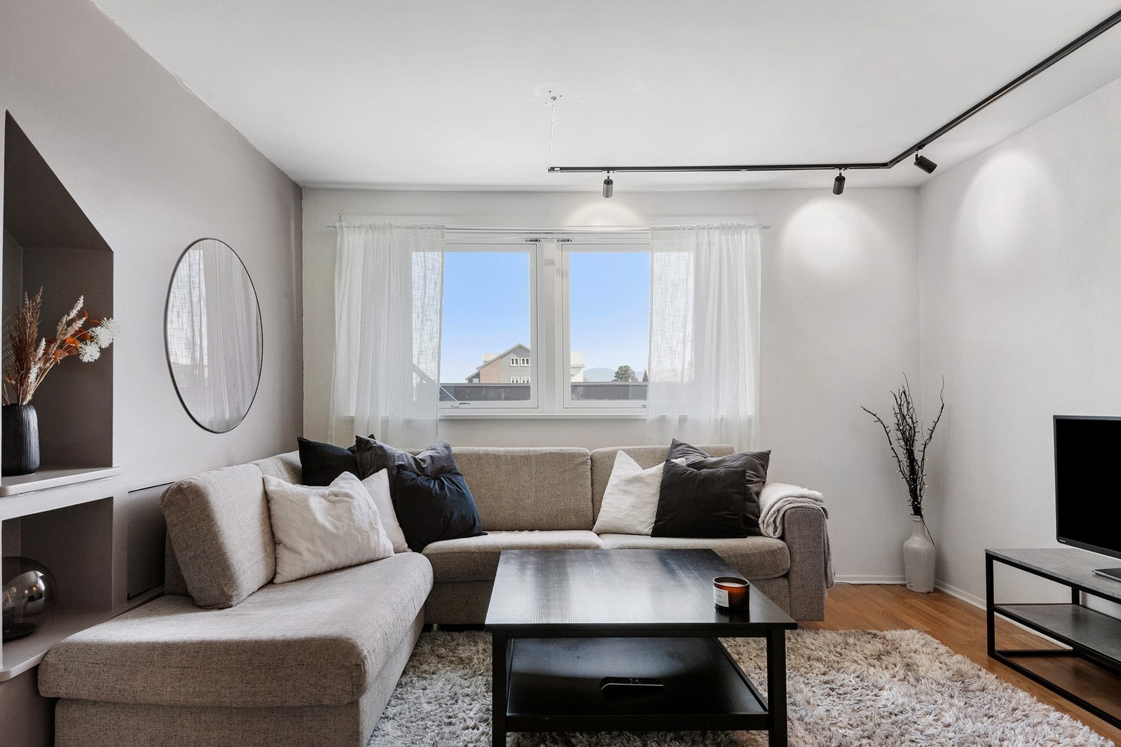 Gjennomgående bruk av 3-stavs parkett på gulv og slette vegger. Bak sofa er det lagt opp til luke for å skjule eventuelle ledninger til TV. Galleribilde