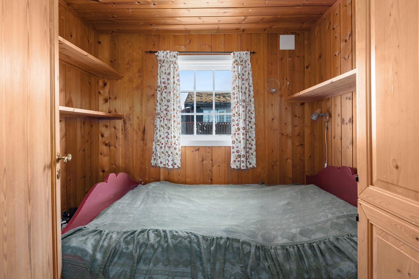 Soverom innredet med dobbeltseng, samt hyller og skap for oppbevaring. Galleribilde