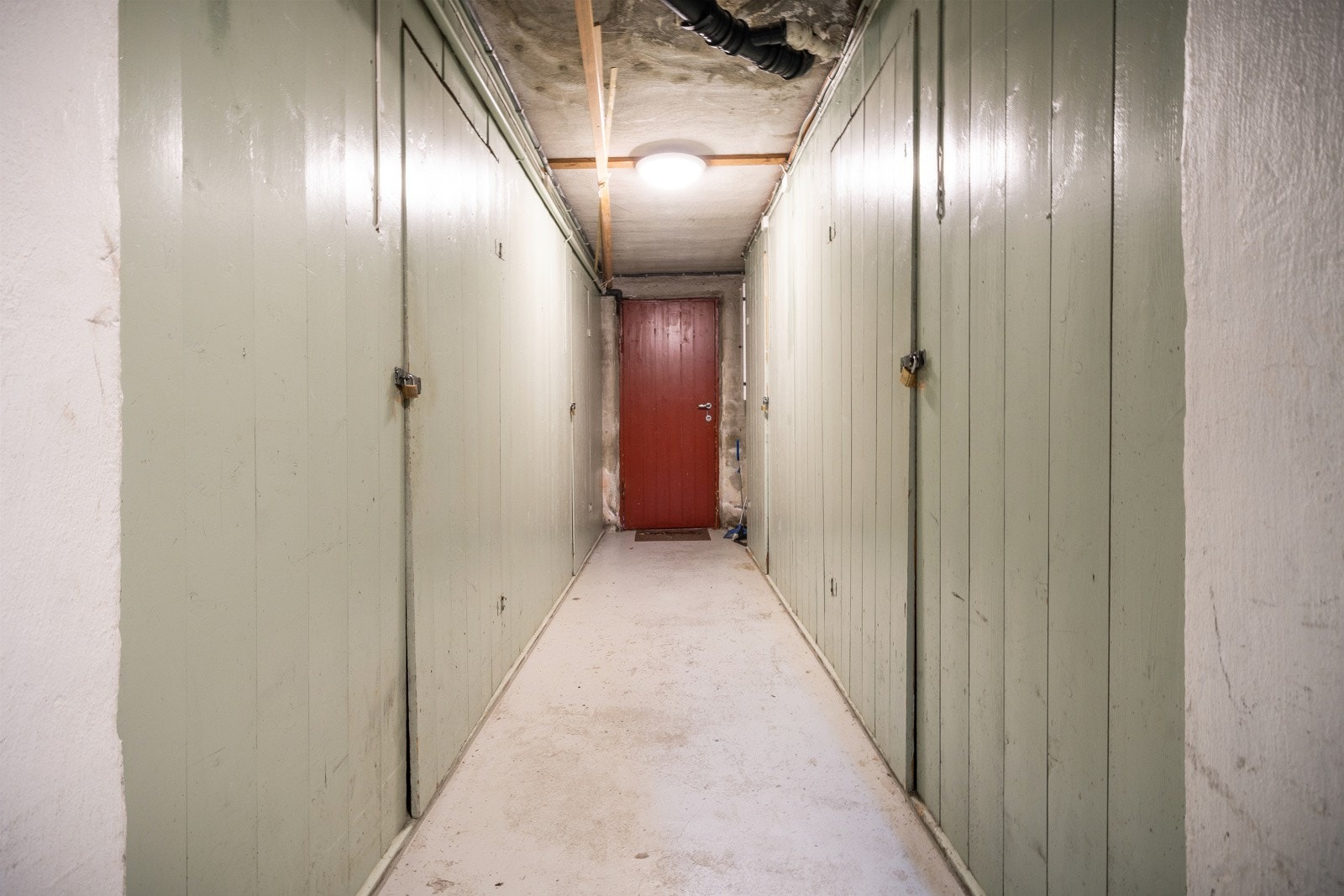 Fra kjellerdøren er det utgang til parkeringsplassen på baksiden av huset. Bodene til leiligheten ligger til venstre i bildet. Galleribilde