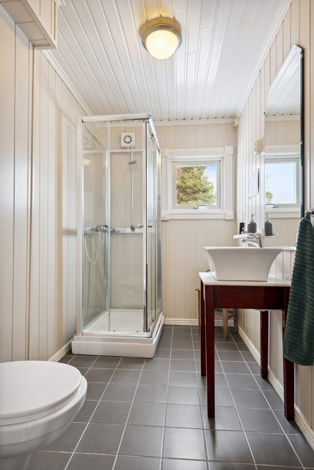 Det er MDF-plater på vegger, malt trepanel i himling og flislagt gulv med varmekabler. Galleribilde