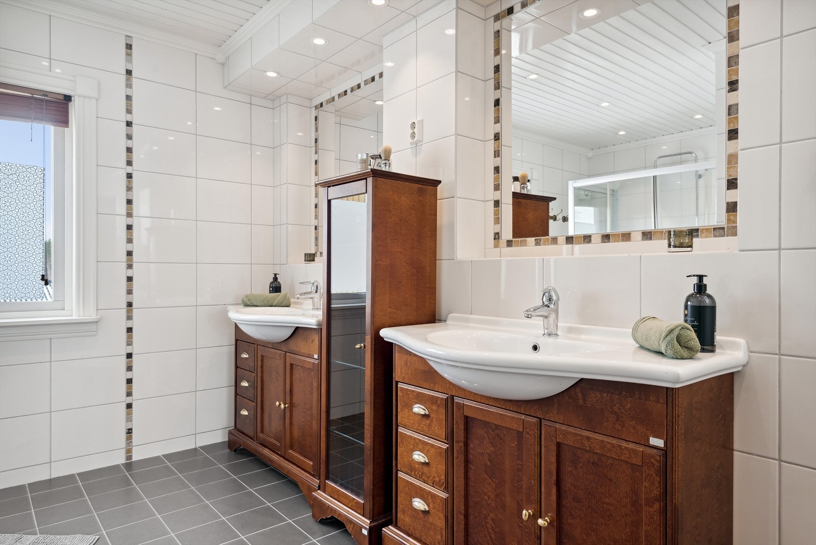 Badet i 2. etasje inneholder åpen dusj med glassvegger, dobbel servantinnredning og vegghengt toalett. Galleribilde