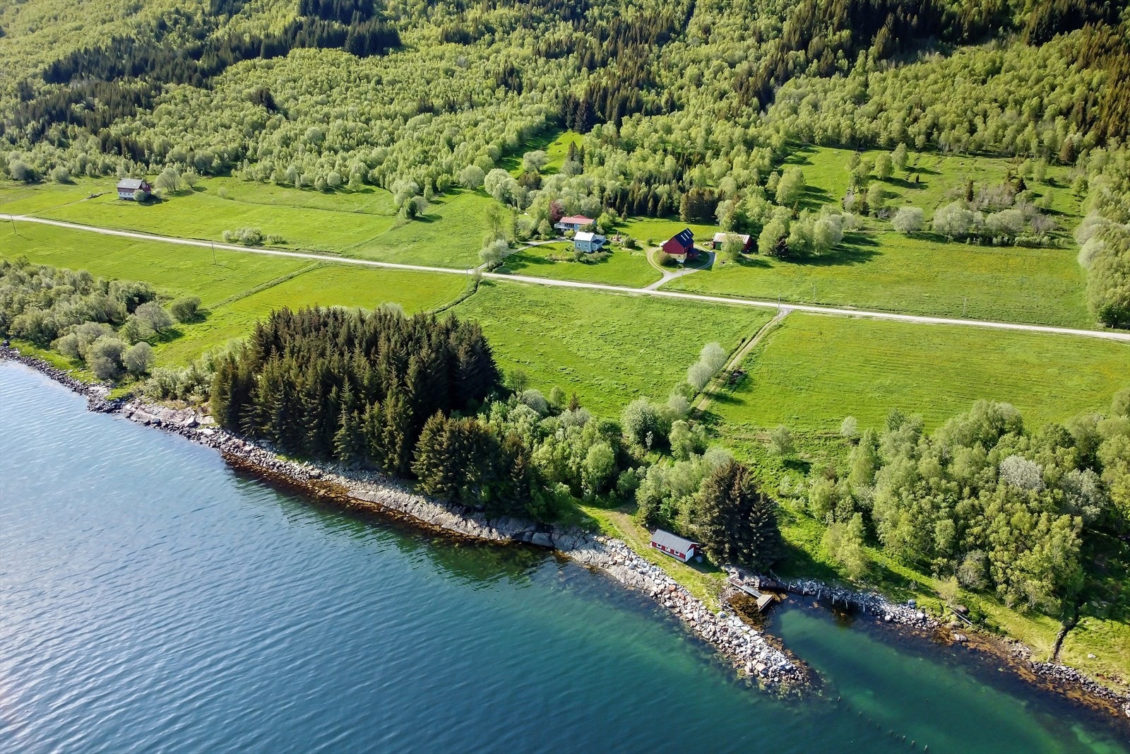 Innholdsrik gård med 2 bolighus, fjøs, garasje og stort redskapshus/lager/garasje samt naust med havneanlegg. Galleribilde