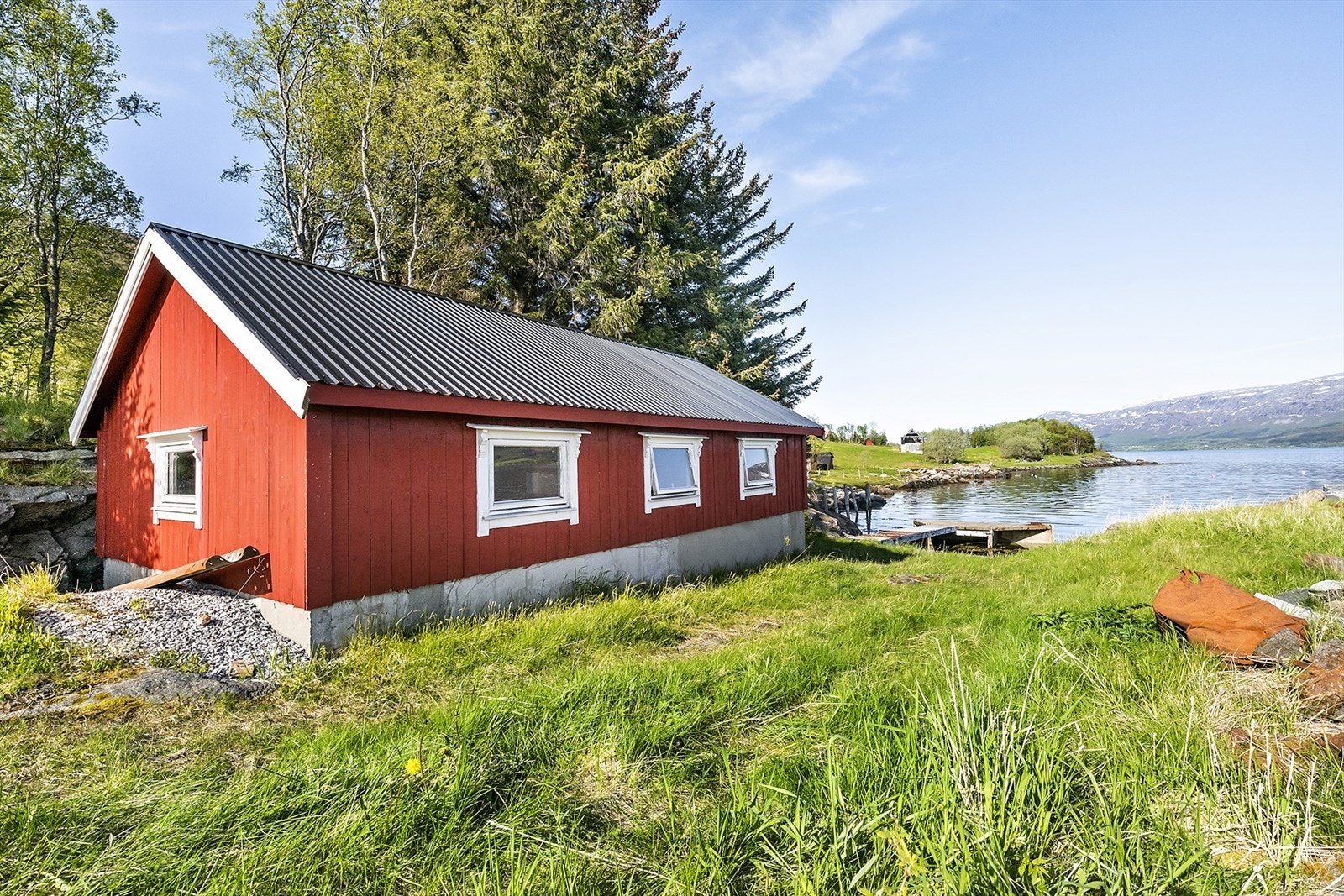 Naust med havneanlegg og molo ligger idyllisk til ved sjøen. Galleribilde