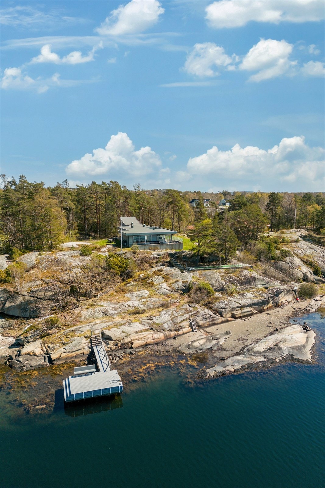 Tomten er over flere nivåer med med svaberg, trær og gressarealer. Galleribilde