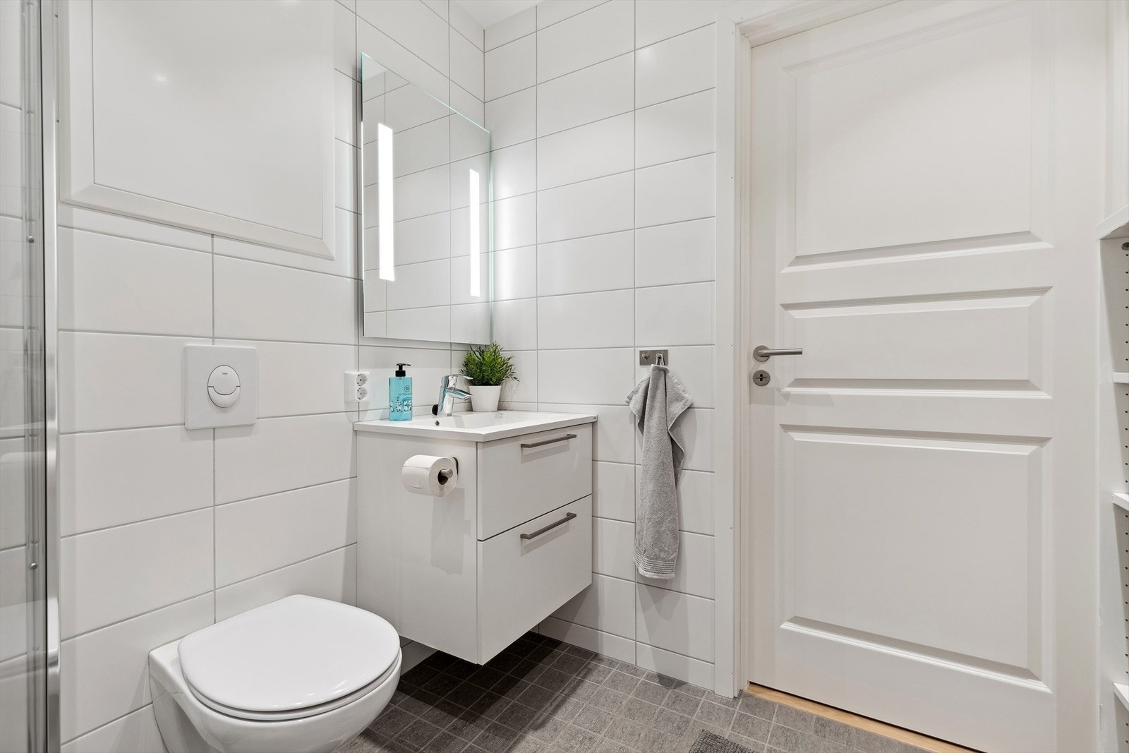 Badet er utstyrt med servant med underskuffer, toalett og dusjhjørne, samt vaskemaskin som medfølger i handelen. Galleribilde