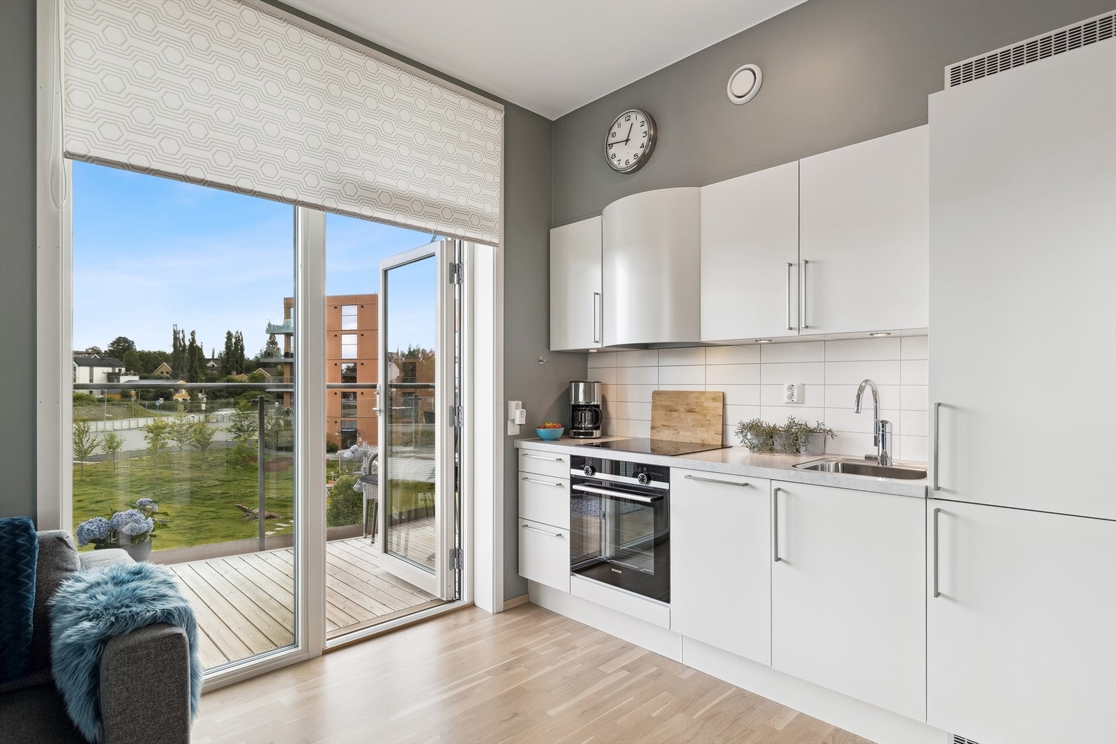 Flott kjøkken med innredning i hvite slette fronter og laminert benkeplate. Galleribilde