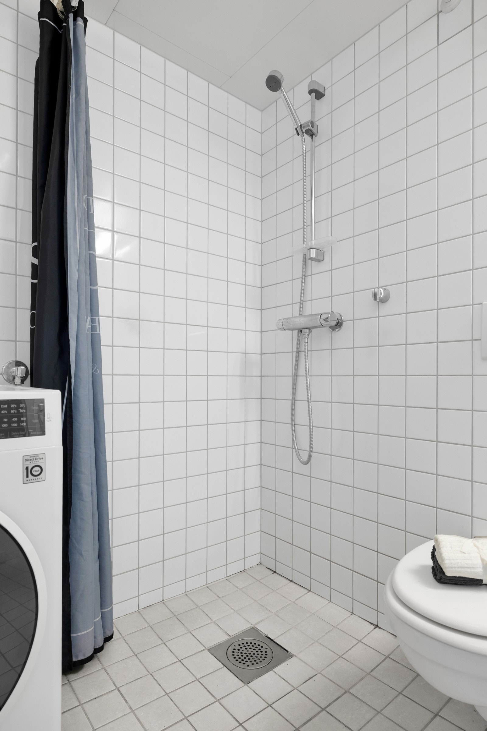 Badet er utstyrt med vegghengt toalett og t åpent dusjhjørne. Galleribilde