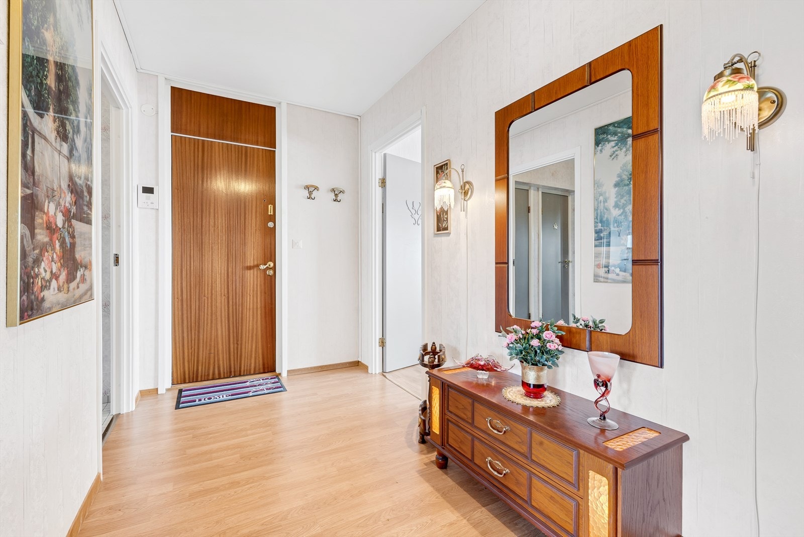 Lys og åpen entré med laminat på gulv, tapet på vegger og malt tak. God plass til garderobeløsninger. Galleribilde