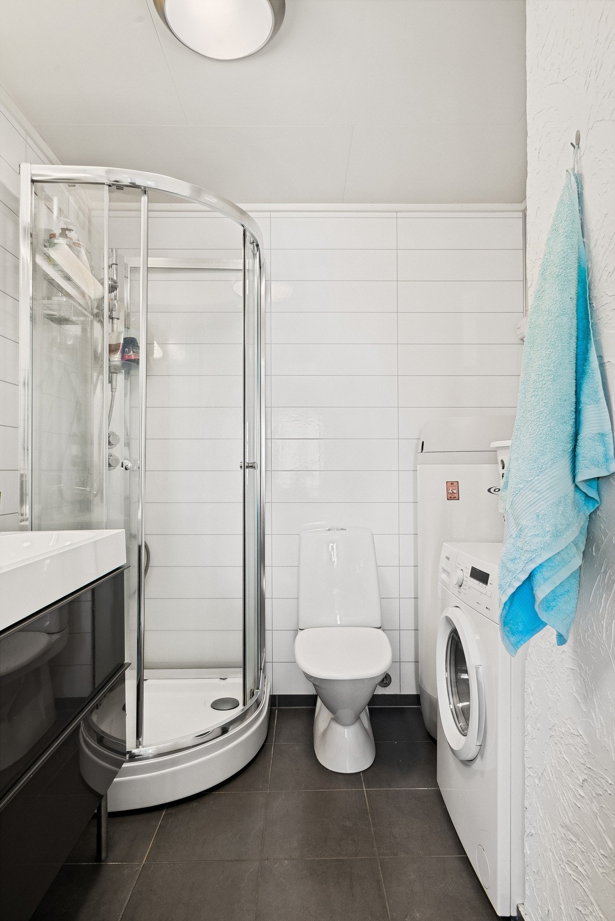 Badet er flislagt på gulvet med smartpanel på veggene Galleribilde