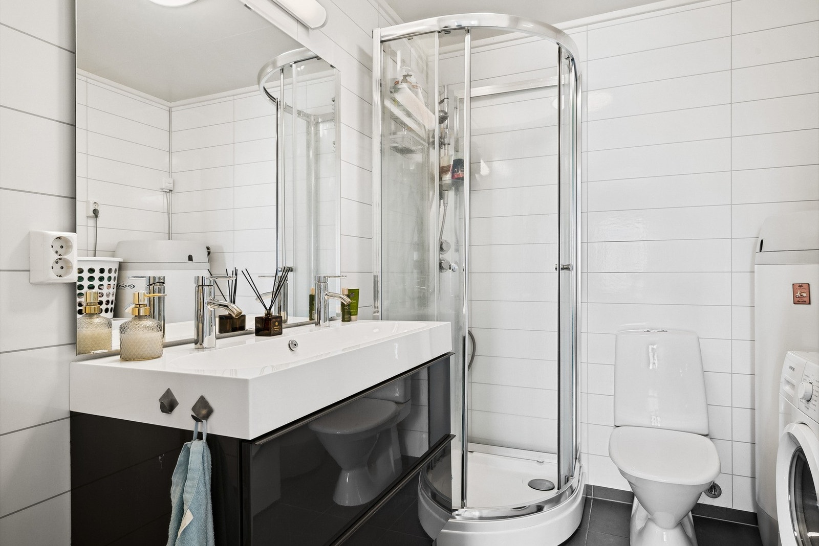 Innredning med skuffer i høyglans og badet har opplegg for vaskemaskin Galleribilde