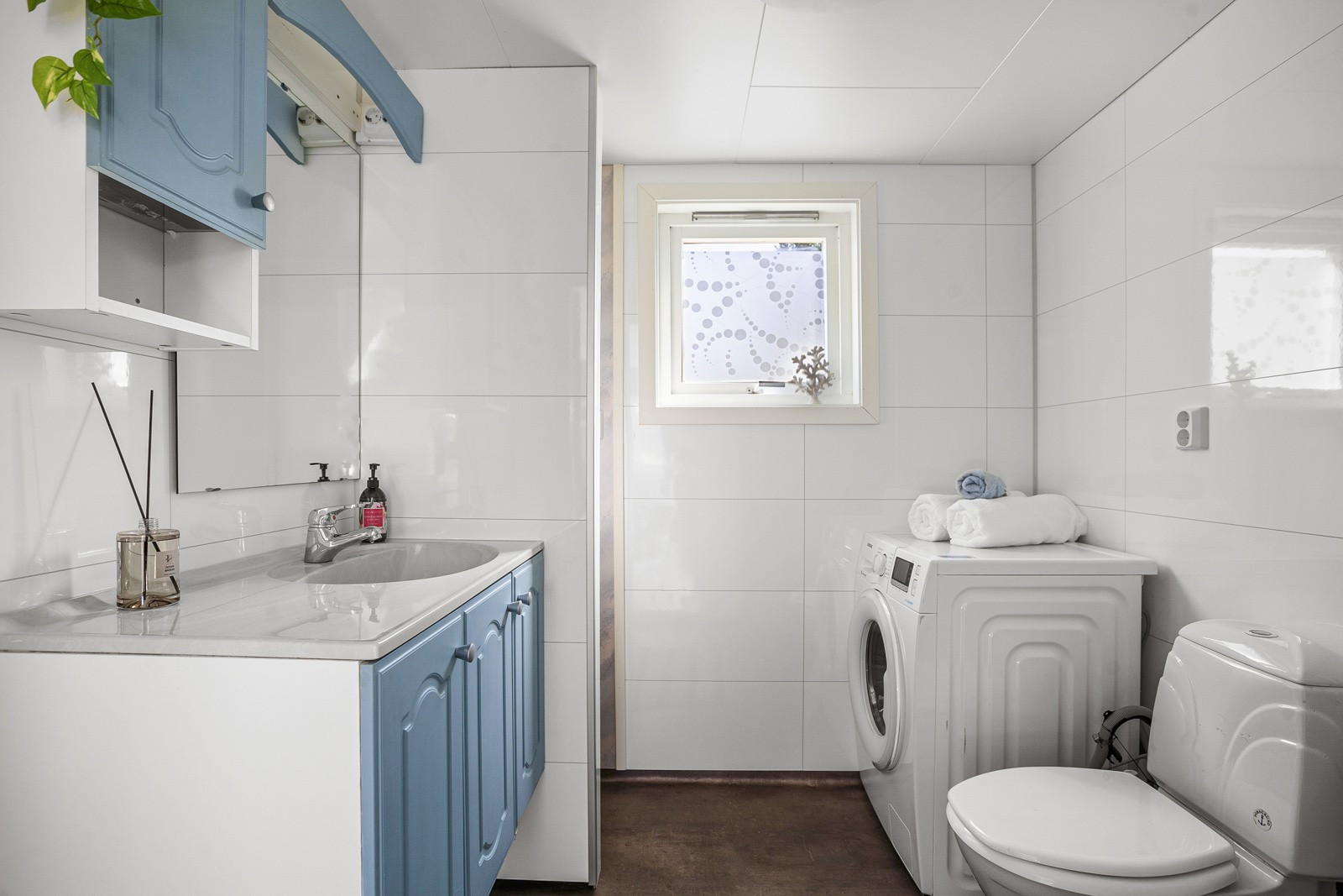 Badet har varme i gulv og er innredet med dusjhjørne, toalett, baderomsinnredning og opplegg for vaskemaskin.