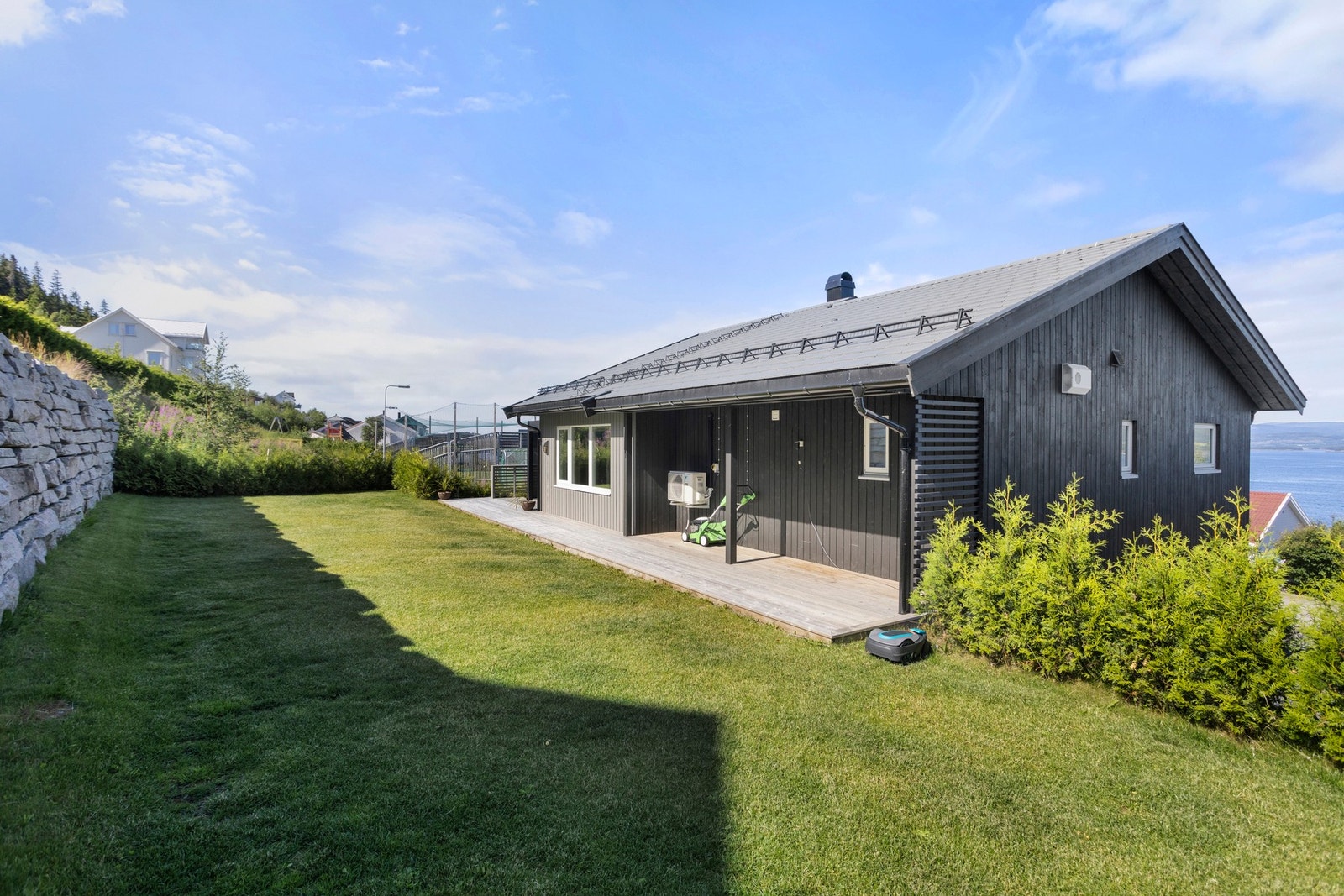 Flat og lettstelt plen på øvre side av boligen Galleribilde