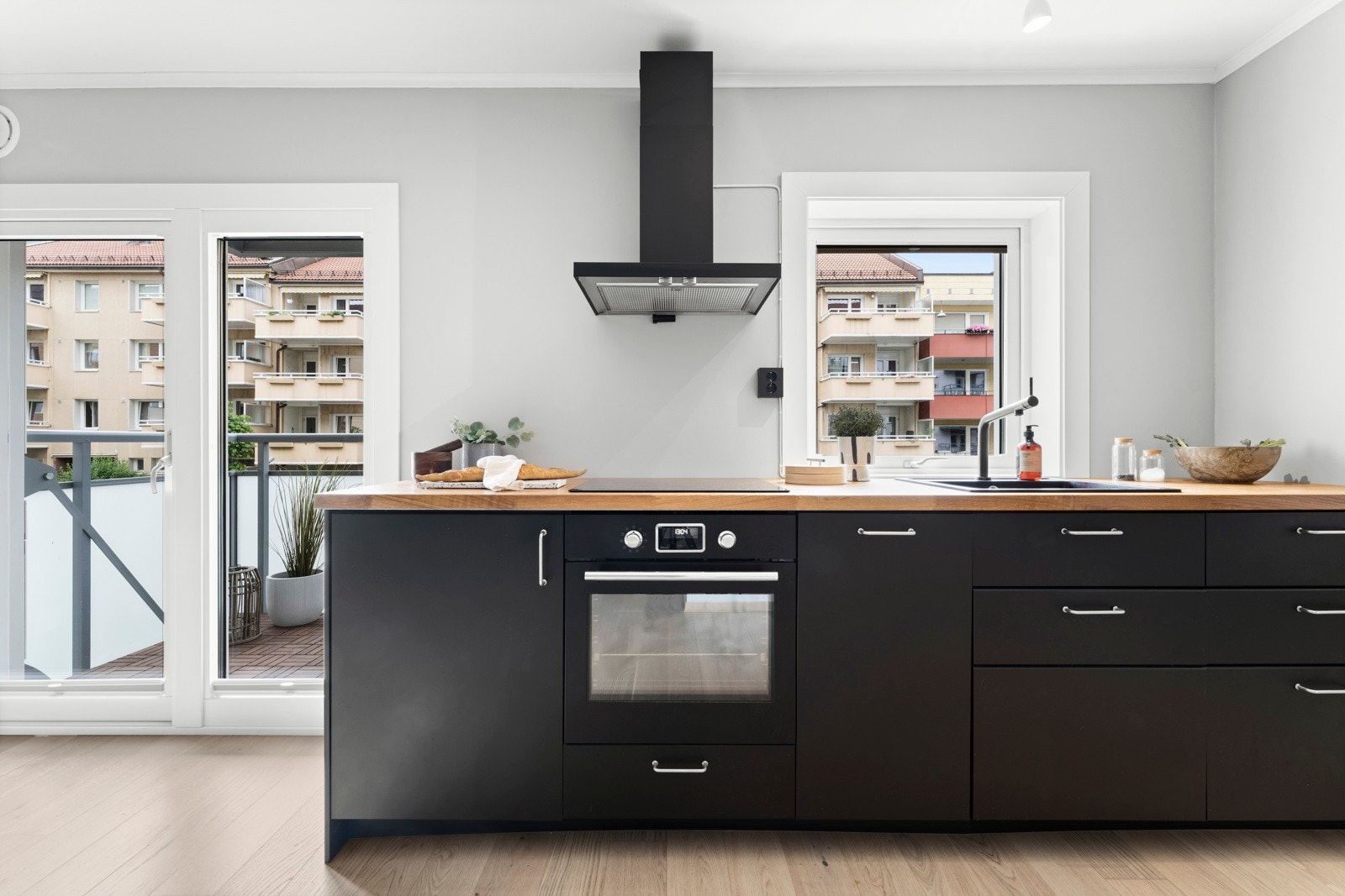 Kjøkkenet har mørk, glatt kjøkkeninnredning, heltre benkeplate og malt flate over benk. Galleribilde