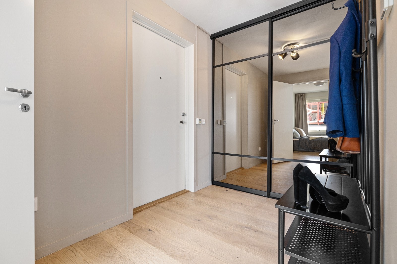 Entréen gir et godt førsteinntrykk av leiligheten med stor skyvedørsgarderobe med speilfronter. Galleribilde