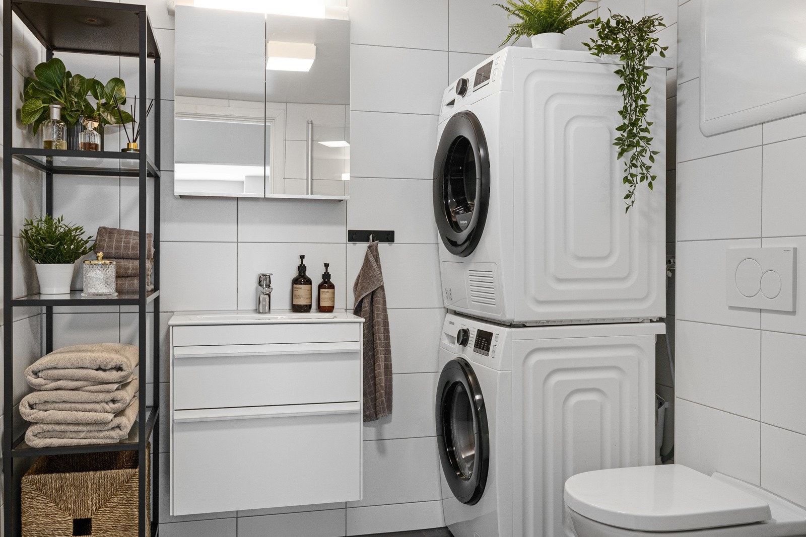 Badet har vegghengt servantinnredning med skuffer, ovenpåliggende servant med ett-greps armatur og speilskap med overlys- og stikkontakt over servant. Galleribilde