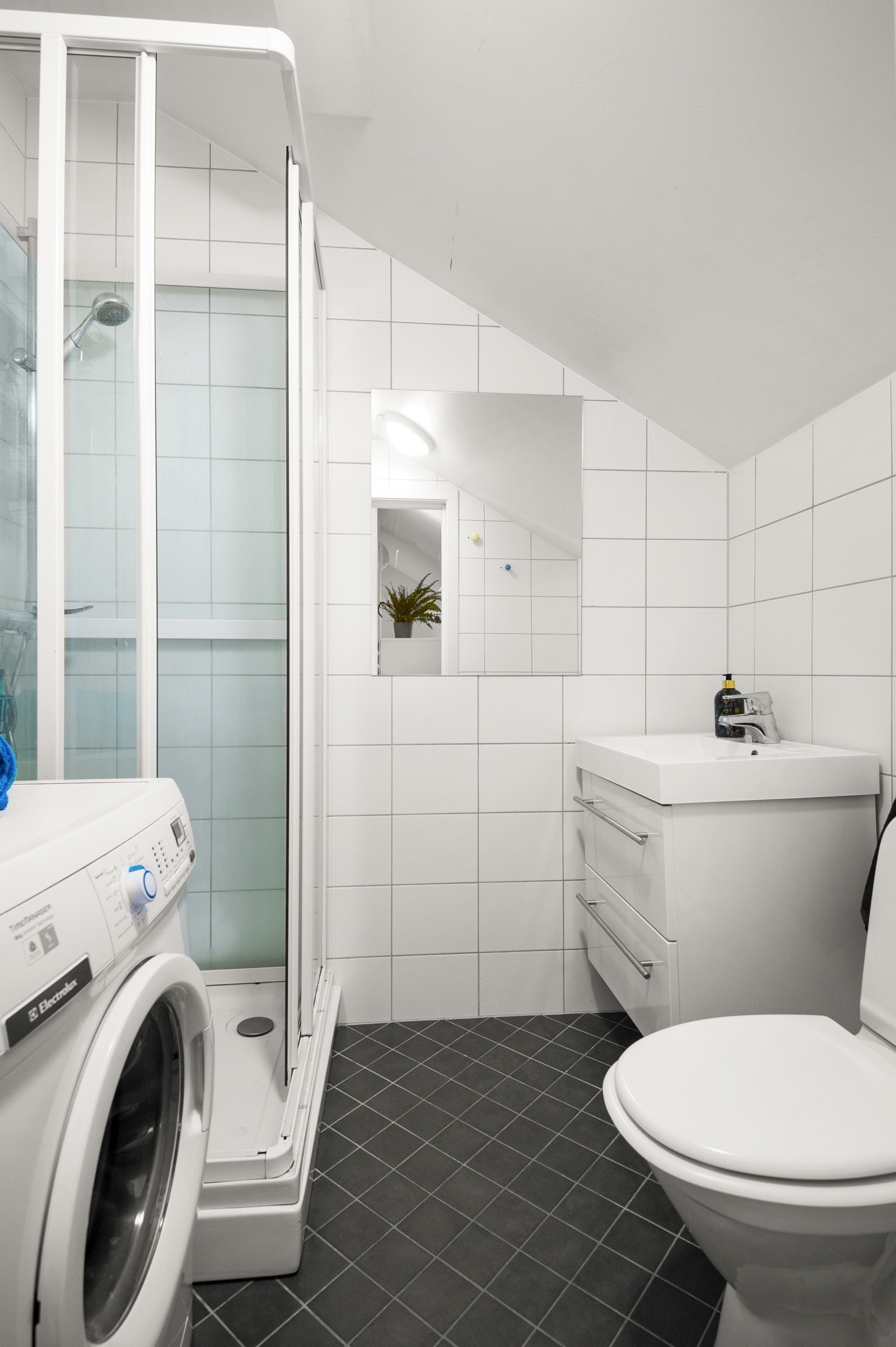 Lyst og flislagt baderom med deilig varme i gulv og opplegg for vaskemaskin. Galleribilde