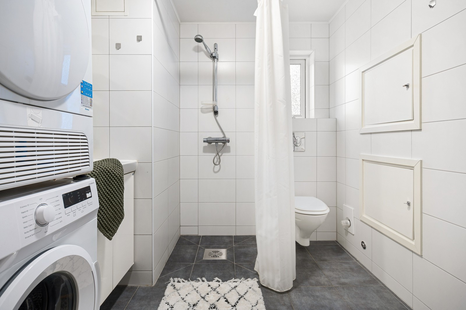 Flislagt bad med plass til vaskemaskin og trommel