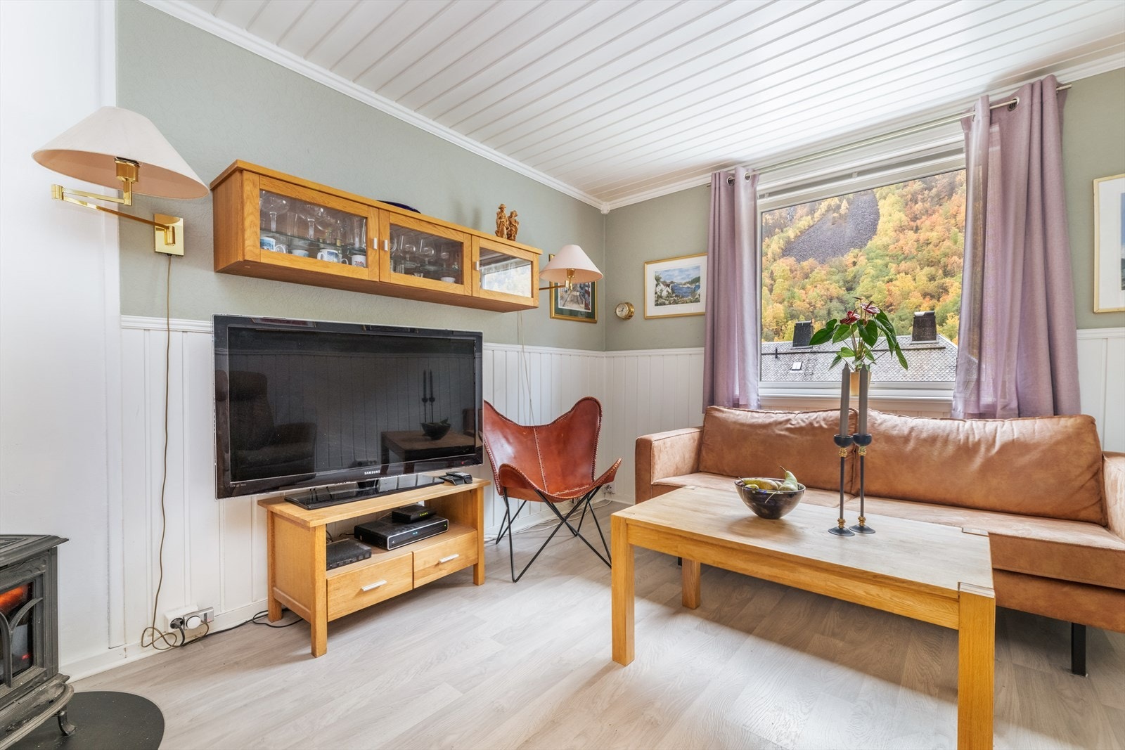 Koselig stue med malt tapet med brystningspanel. Galleribilde