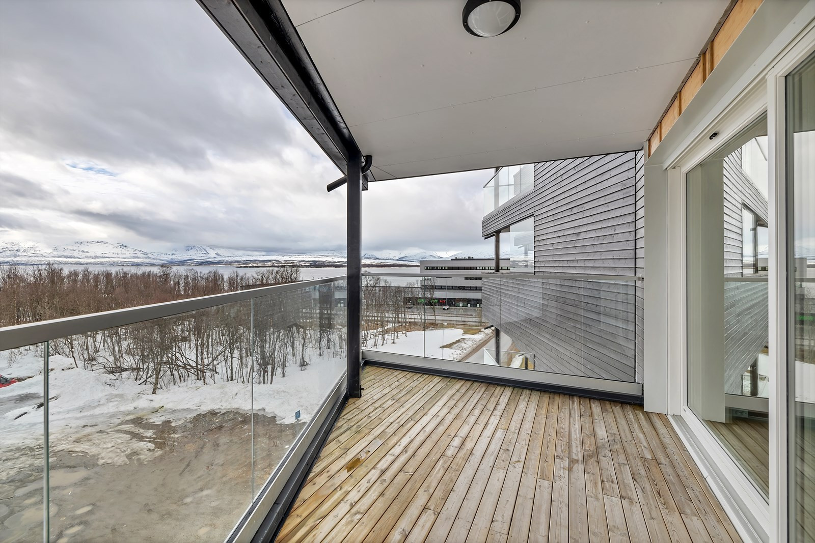 Sørvendt veranda med takoverbygg - utsikt mot Sandnessundet og Kvaløya.