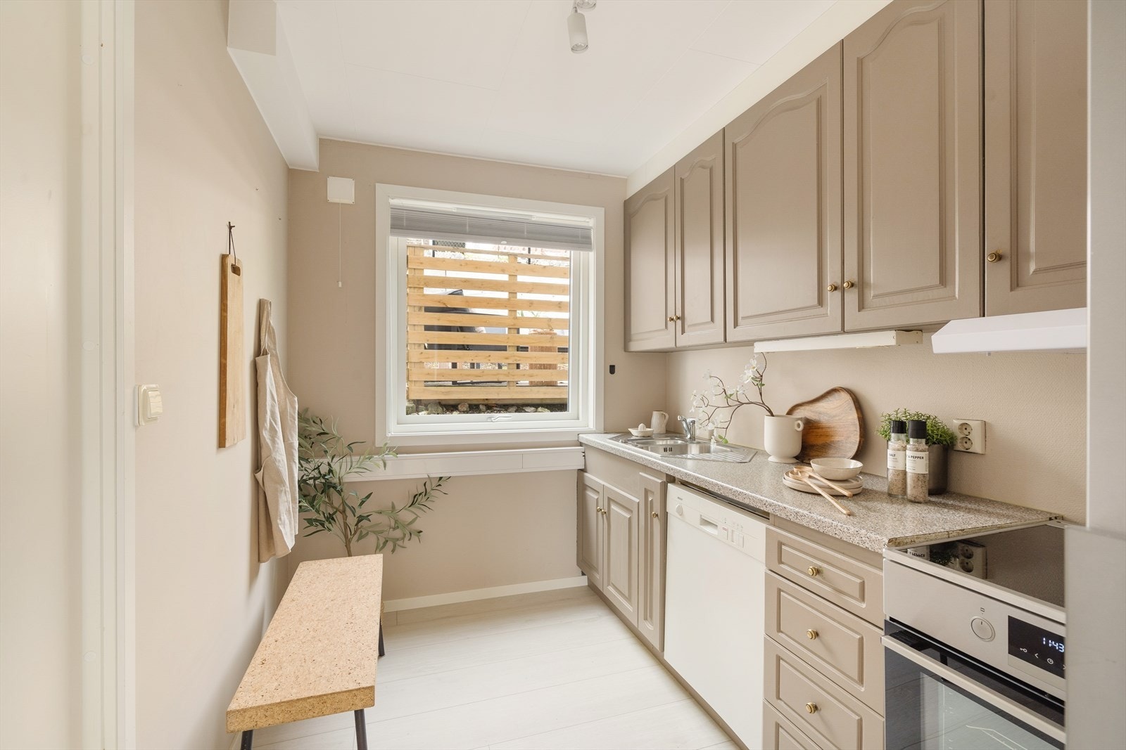 Kjøkkenet har innredning med profilerte fronter og benkeplate av laminat. Det er kjøl/fryseskap, oppvaskmaskin og komfyr. Galleribilde