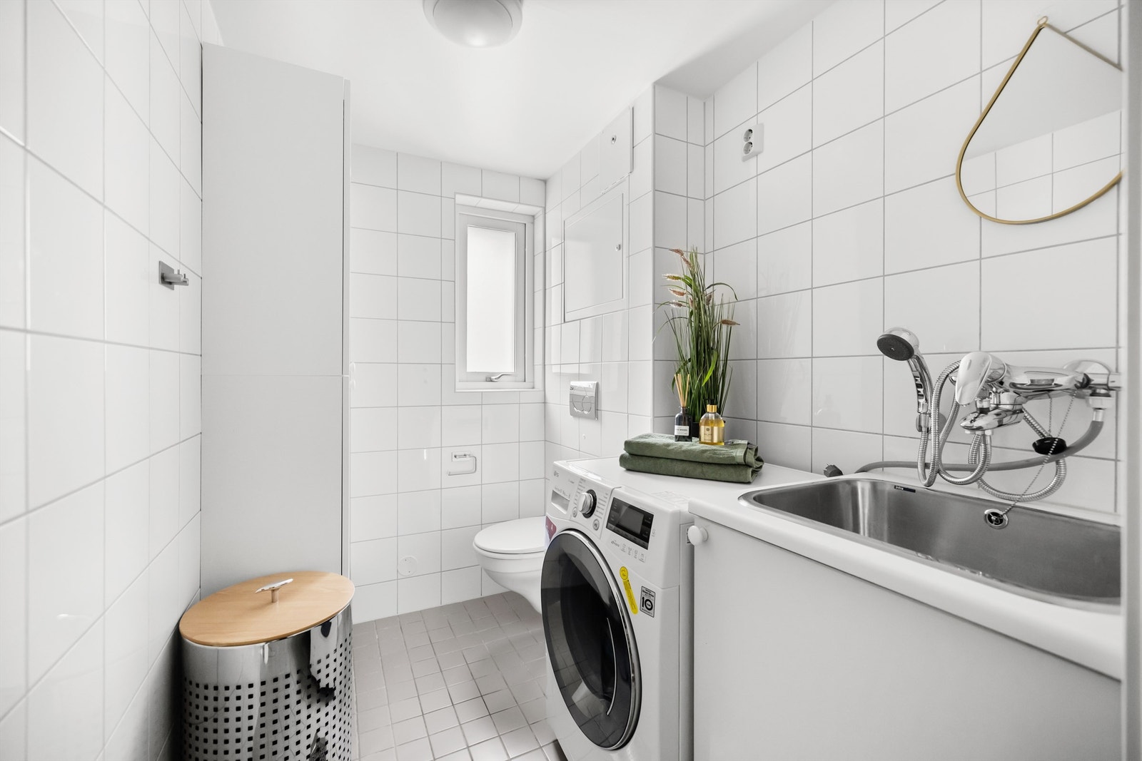 Leiligheten inneholder også et separat flislagt vaskerom med gulvvarme. Vaskerommet inneholder også et toalett. Galleribilde