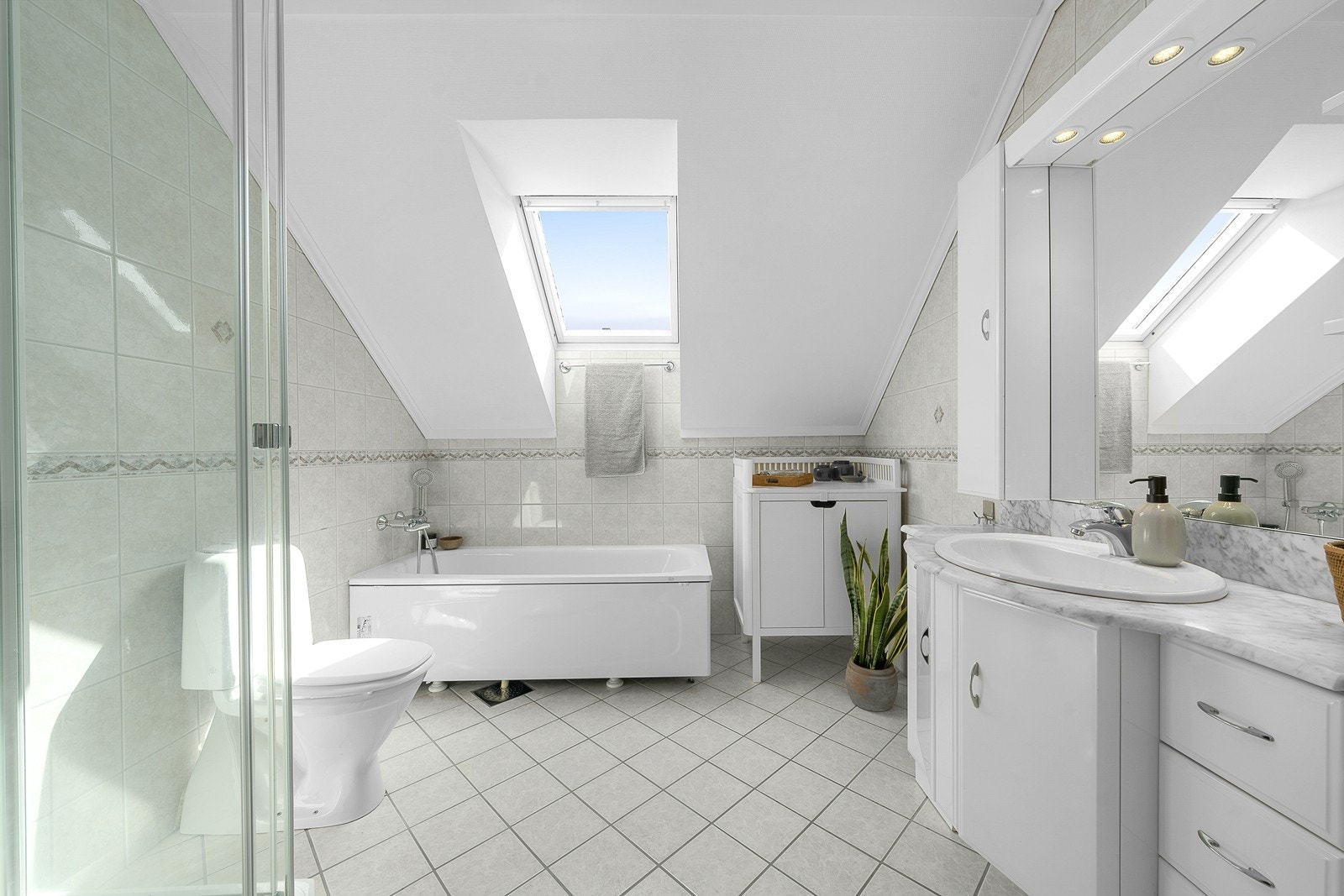 Hovedbadet er lyst og pent, med både toalett, dusj, badekar og et stort baderomsmøbel. Galleribilde