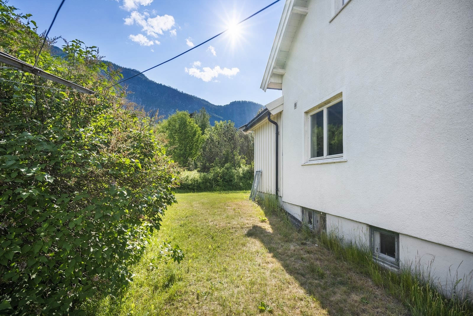 Tomten er opparbeidet med plen og beplantning, men har også belegningsstein, gruset tilkomstvei og gårdsplass. Galleribilde