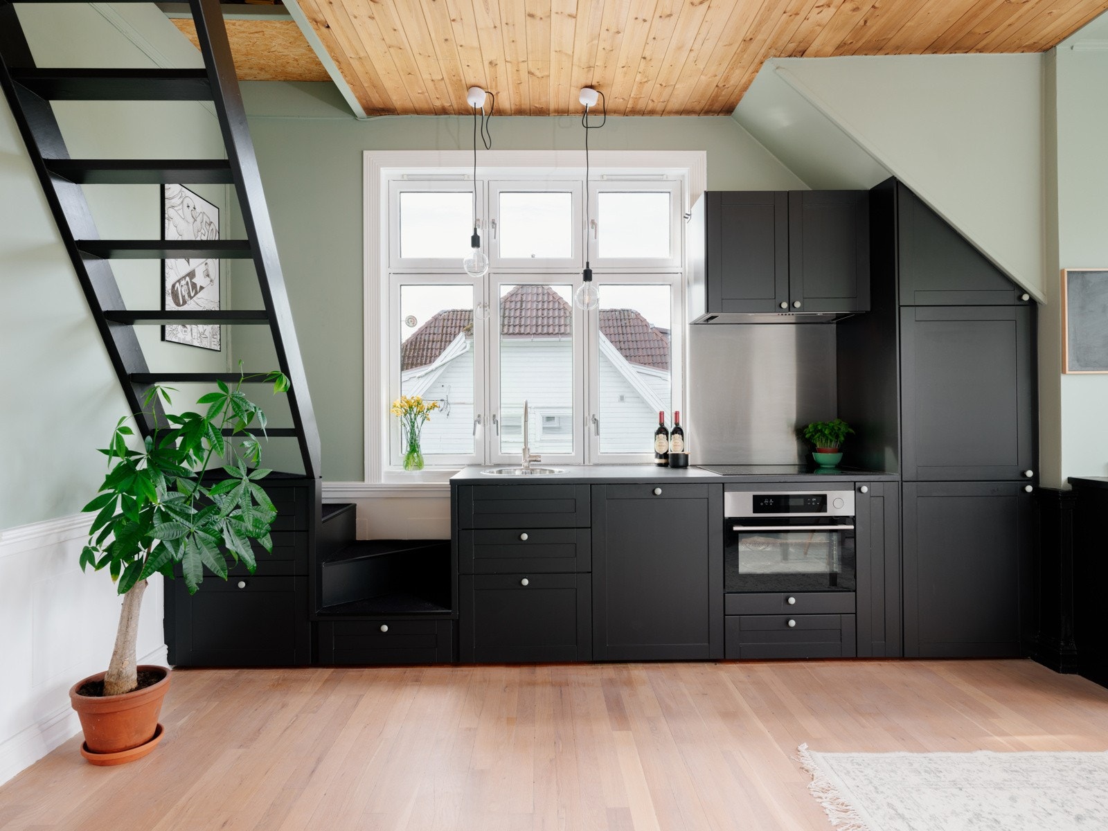 Kjøkkeninnredning med sortmalte profilerte fronter og laminert benkeplate med nedsenket oppvaskkum. Kjøkkenet er fullt utstyrt med integrerte hvitevarer som medfølger i handelen. Galleribilde