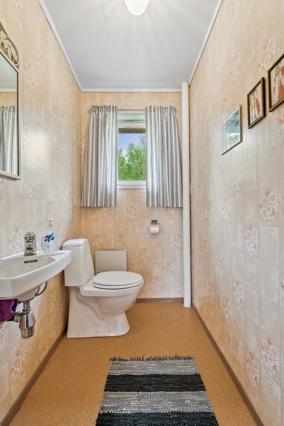 Vegg-i-vegg med badet finner du toalettrommet - Enkelt innredet med gulvmontert toalett og servant Galleribilde