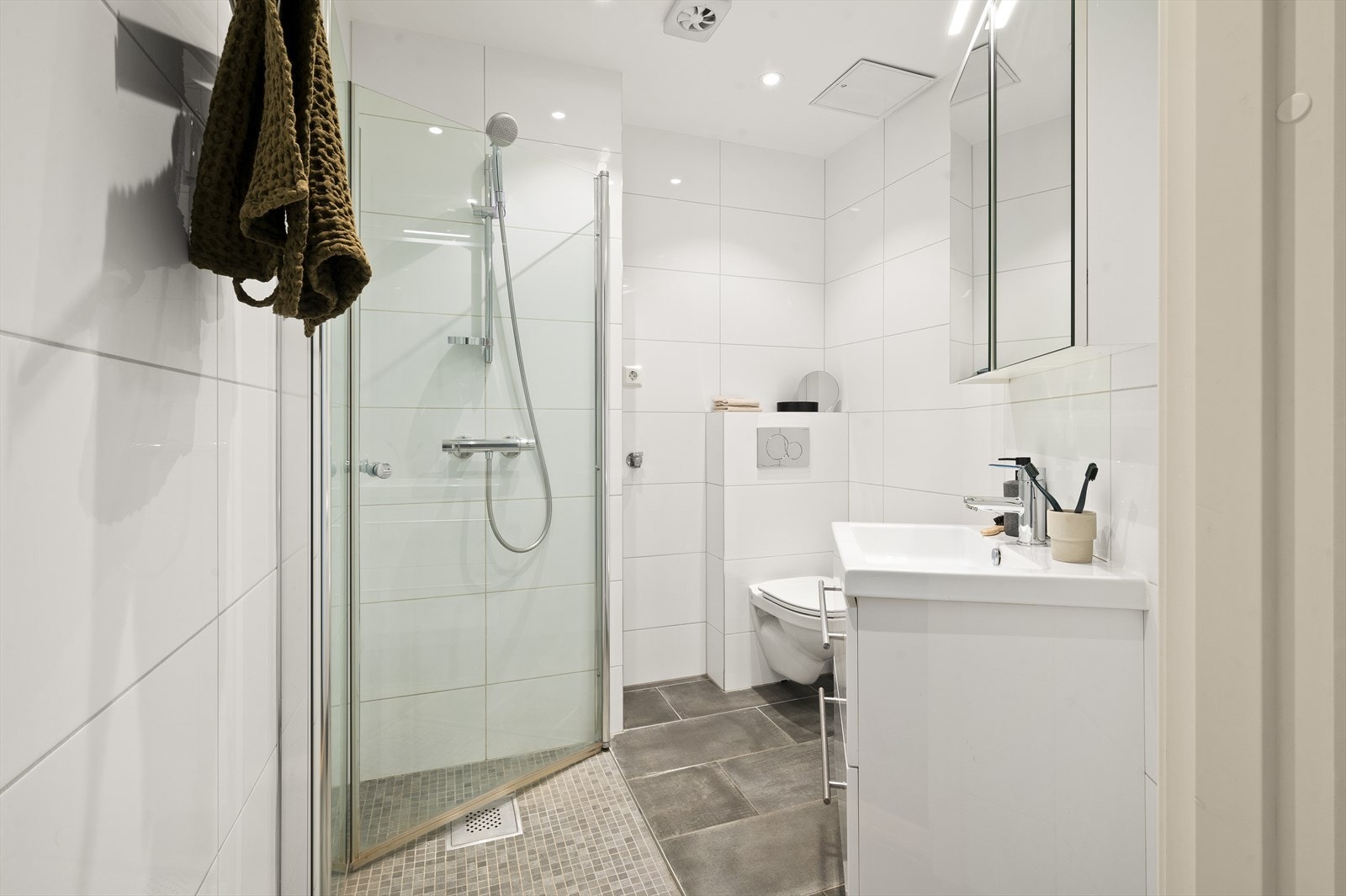 Delikat og flislagt baderom med gulvvarme som ble rehabilitert i 2015. Baderommet inneholder dusjhjørne med svingbare dusjvegger av herdet glass og termostat dusjbatteri, vegghengt wc og servantskap med skuffer Galleribilde