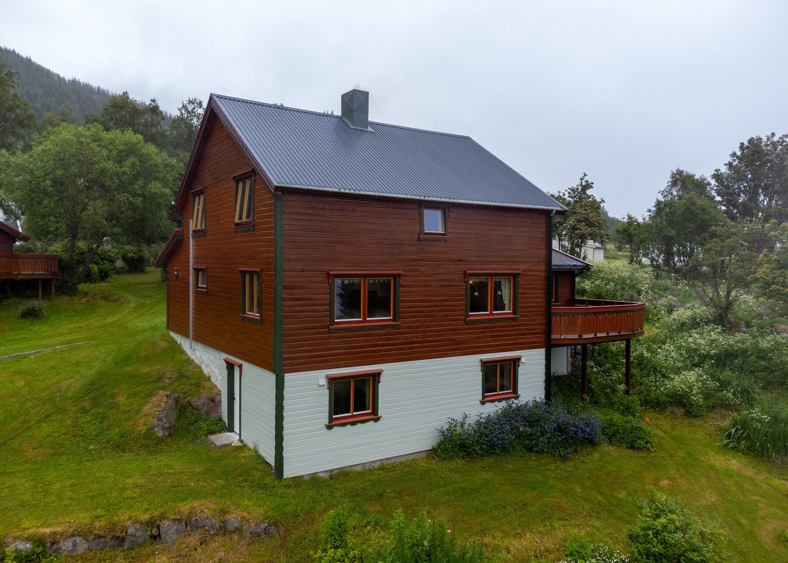 Uteområdet er pent opparbeidet med plen og beplantning. Gruset innkjørsel og gårdsplass. Galleribilde