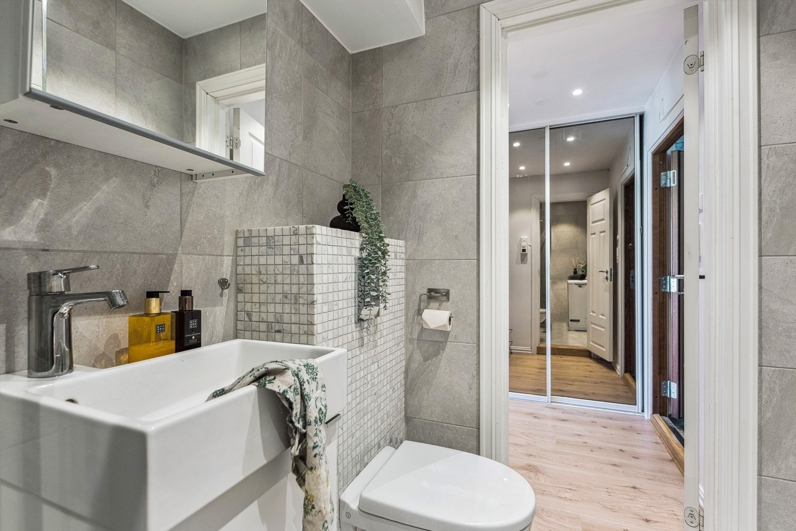 Badet er funksjonelt og med inngangen er fra gangen. I gangen er det skyvedørsgarderobe med speilfronter. Galleribilde