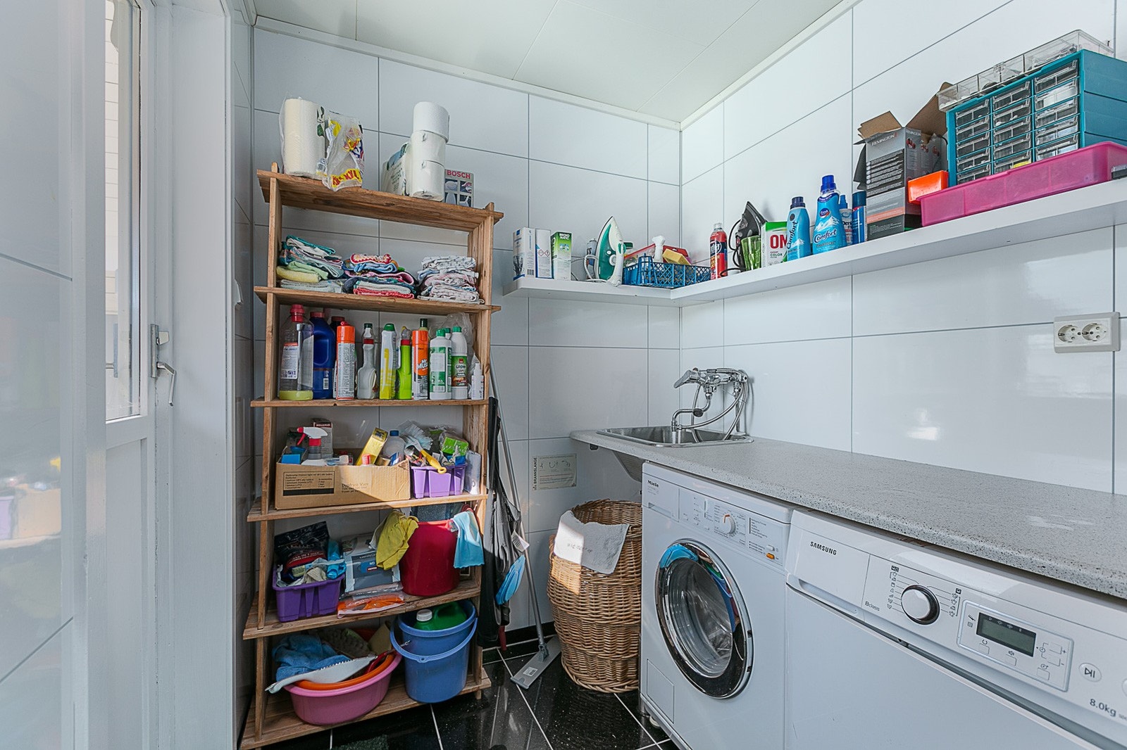 Badet har egen, avdelt sone for vaskemaskin og utgangsdør. Galleribilde