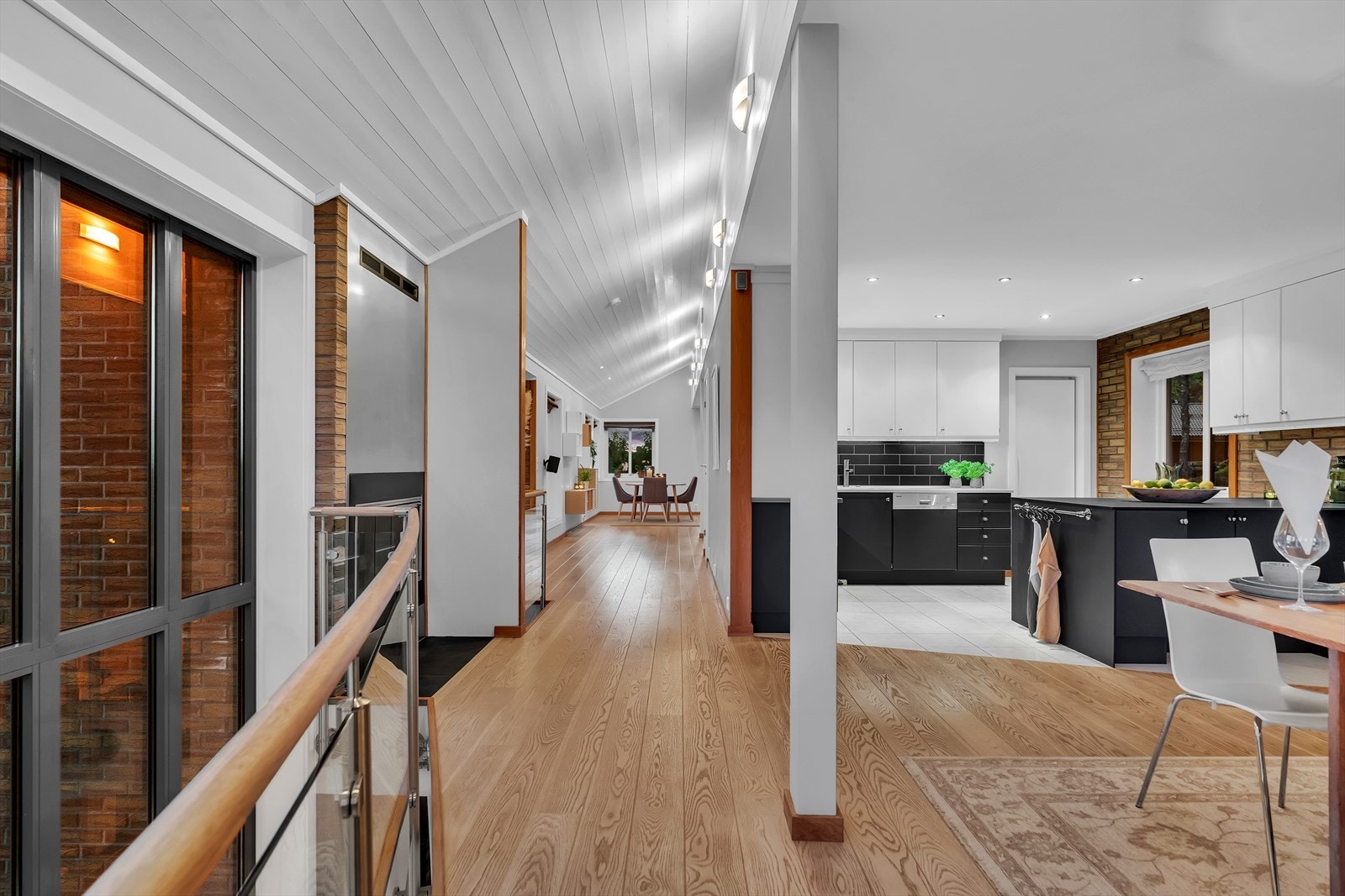 Store vinduer på to sider åpner for dagslys og god kontakt med hagen, mens downlights og vegglamper montert i høyden gir behagelig kveldsbelysning. Galleribilde