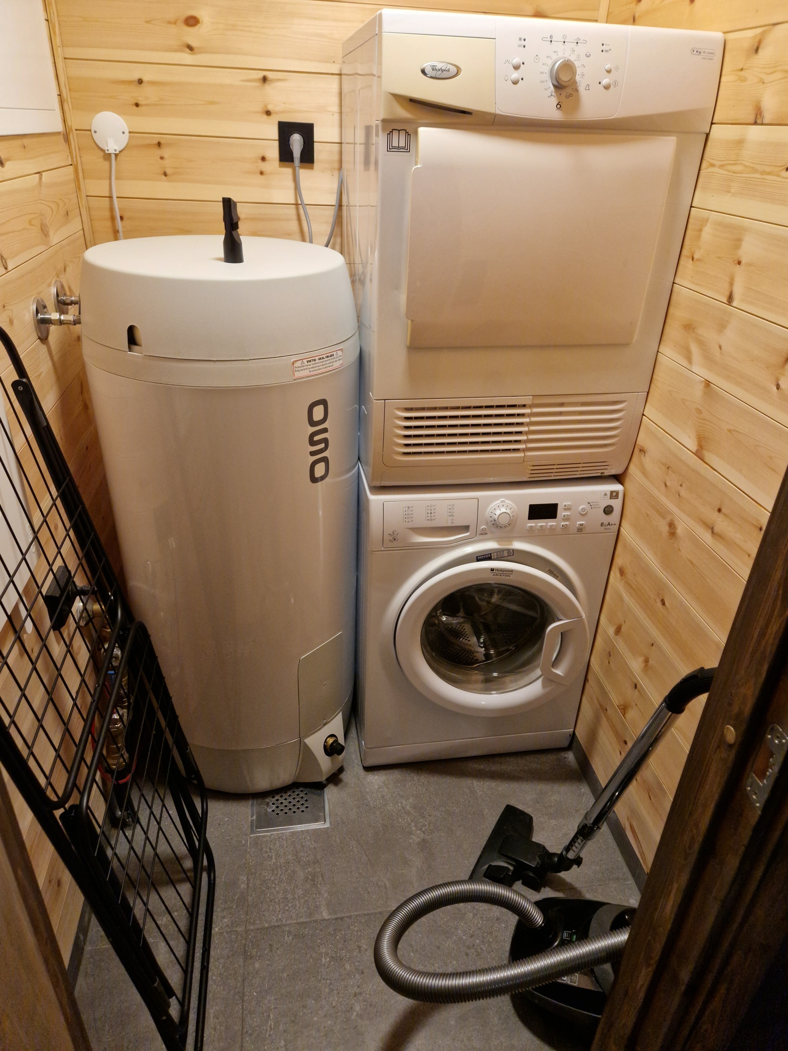 Vaskerommet utstyrt med vaskemaskin, tørketrommel, tørkestativ og støvsuger Galleribilde